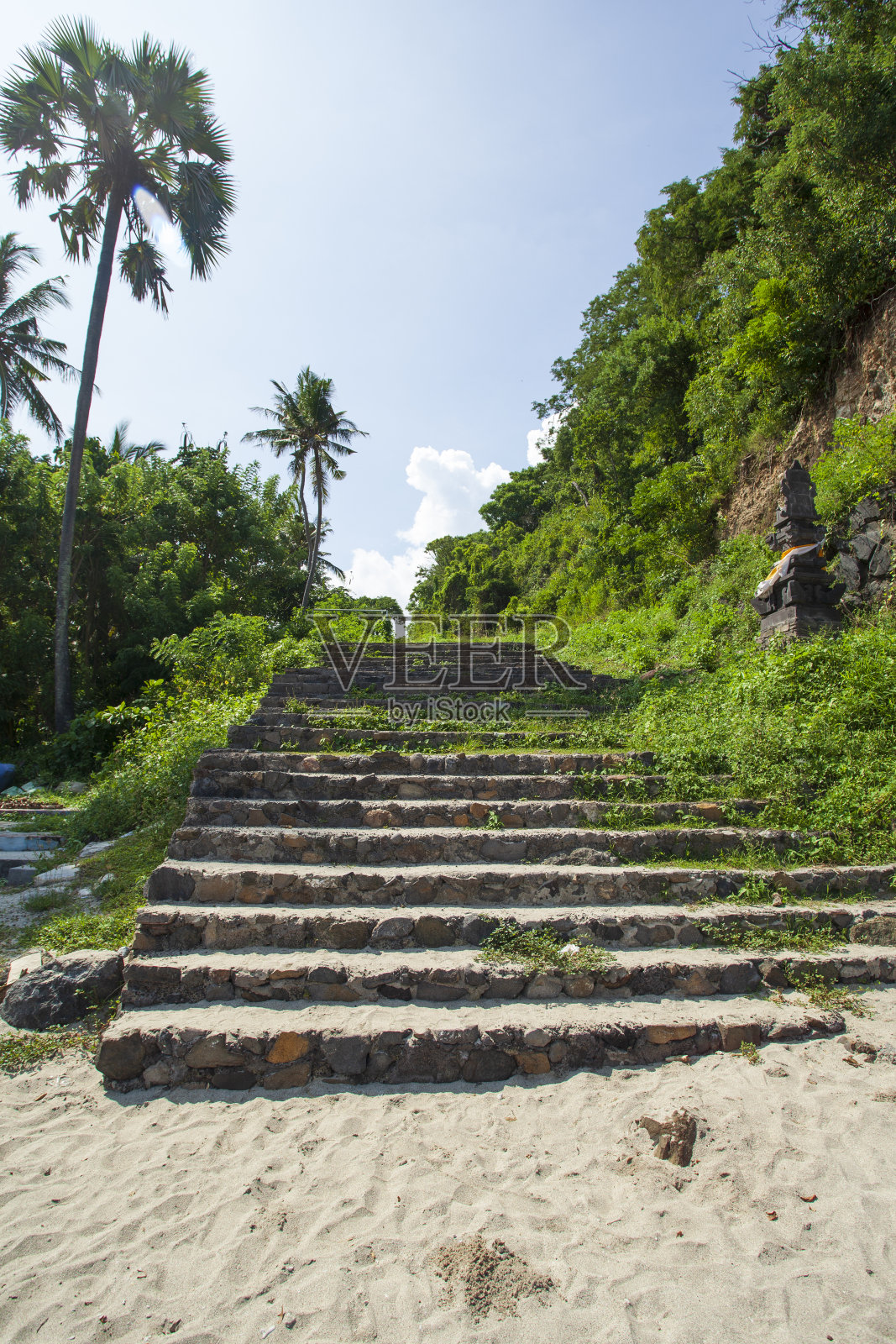 通往印度尼西亚东巴厘岛白色沙滩的旧台阶照片摄影图片