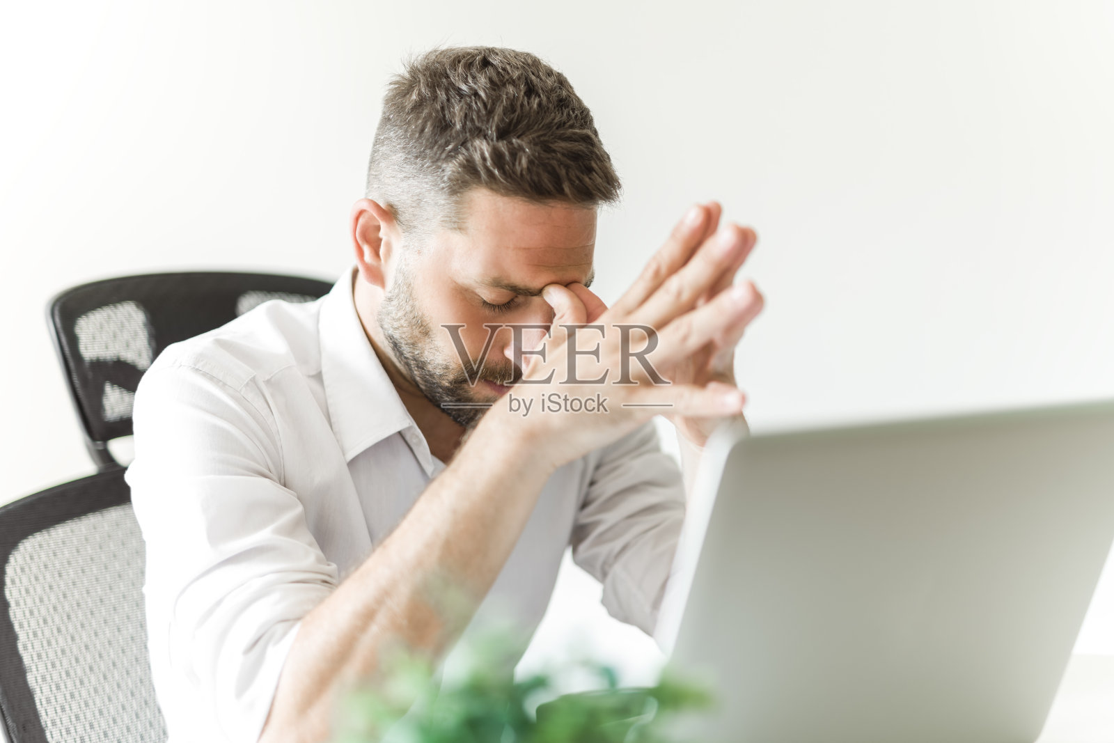 在办公室使用笔记本电脑的成熟商人看起来很沮丧照片摄影图片