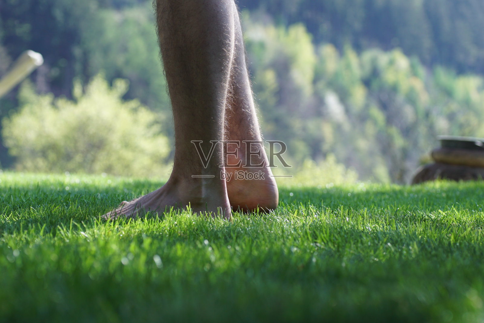 赤脚站在草地上的男人。照片摄影图片