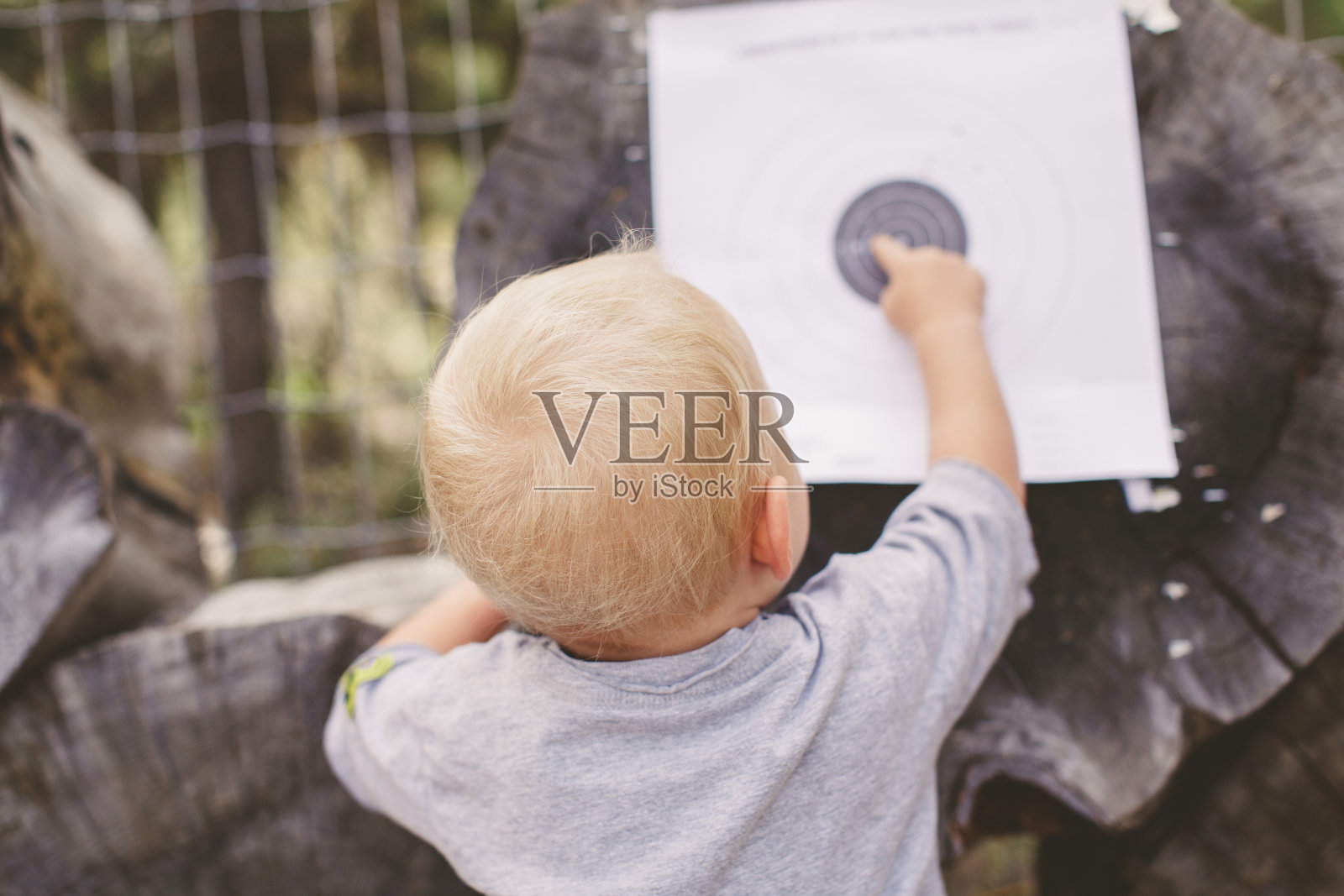 蹒跚学步的小女孩在森林里检查目标板照片摄影图片