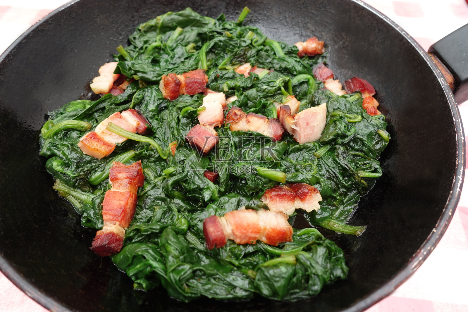 菠菜和炸培根片一起在锅里煮照片摄影图片