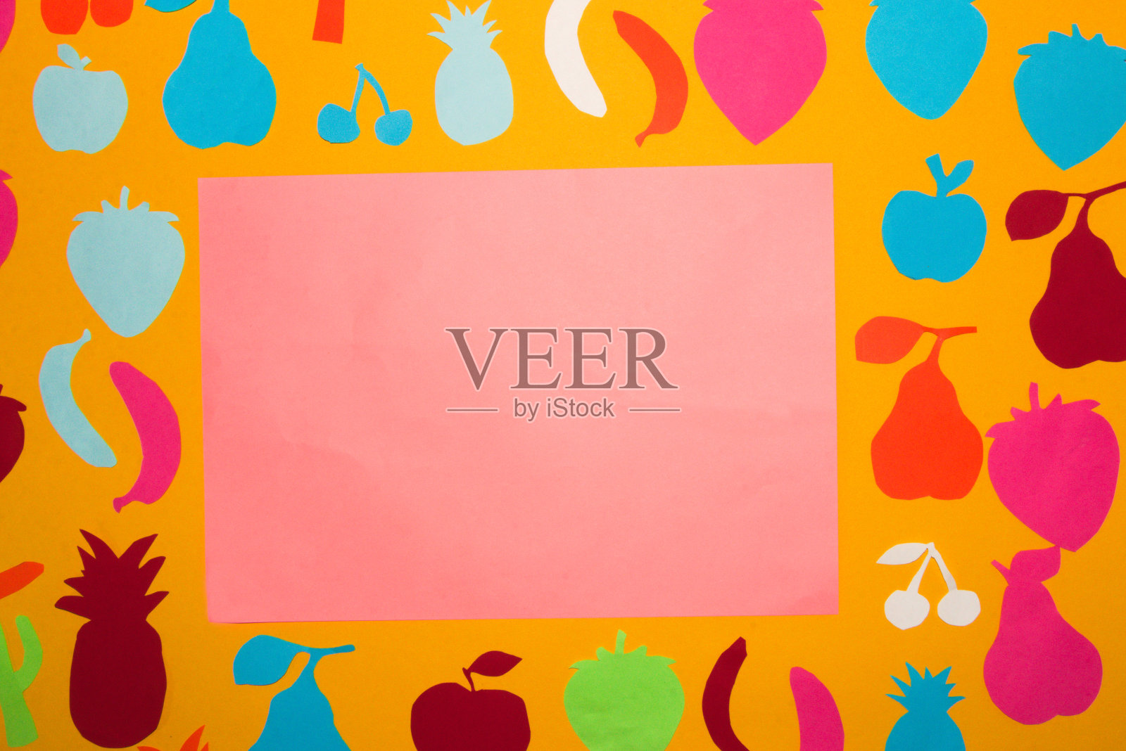 粉色空白纸为拷贝空间，周围以橙色为背景，彩色纸水果，创意概念，维生素照片摄影图片