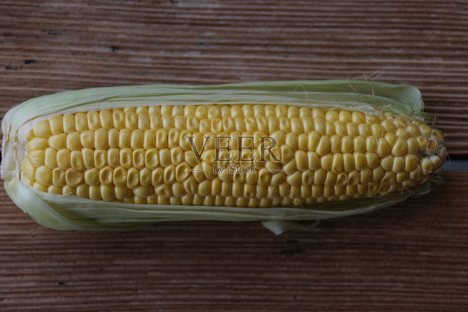 木桌上的玉米棒子照片摄影图片