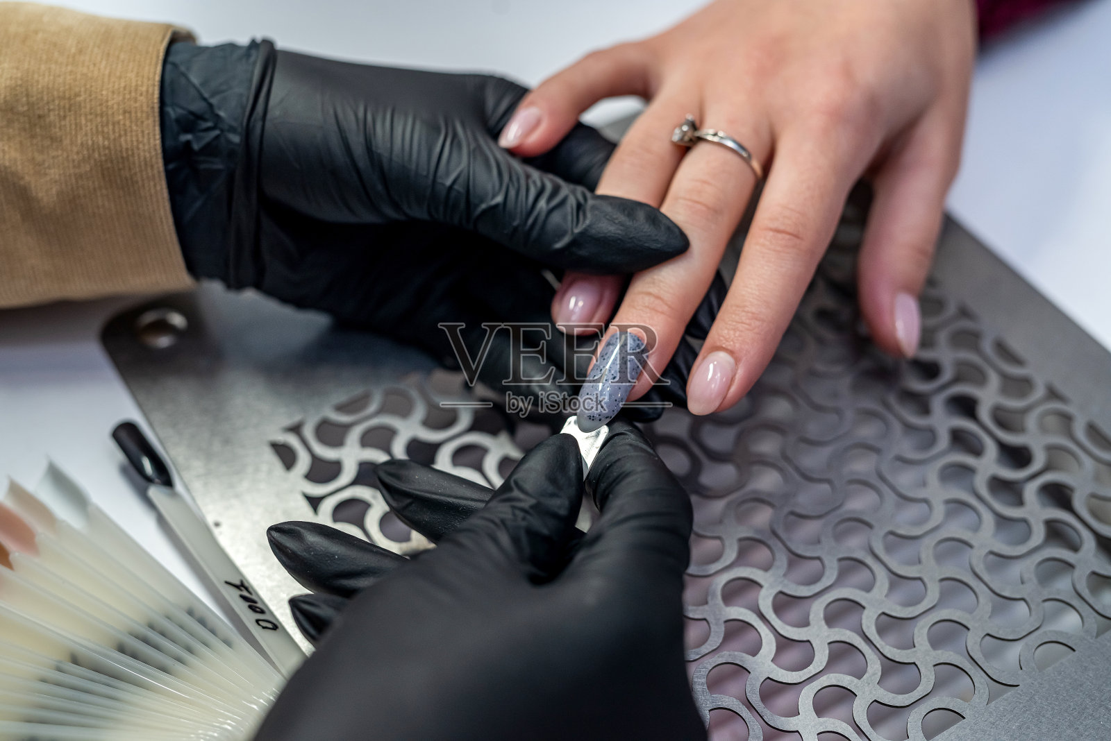 客户与主人在修甲柜挑选颜色的指甲油照片摄影图片