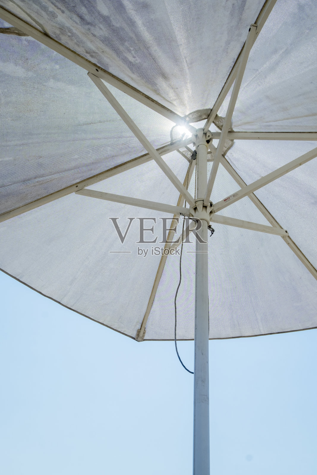 白色的遮阳伞映衬着深蓝色的天空，暗示着佛罗里达炎热的夏日。照片摄影图片