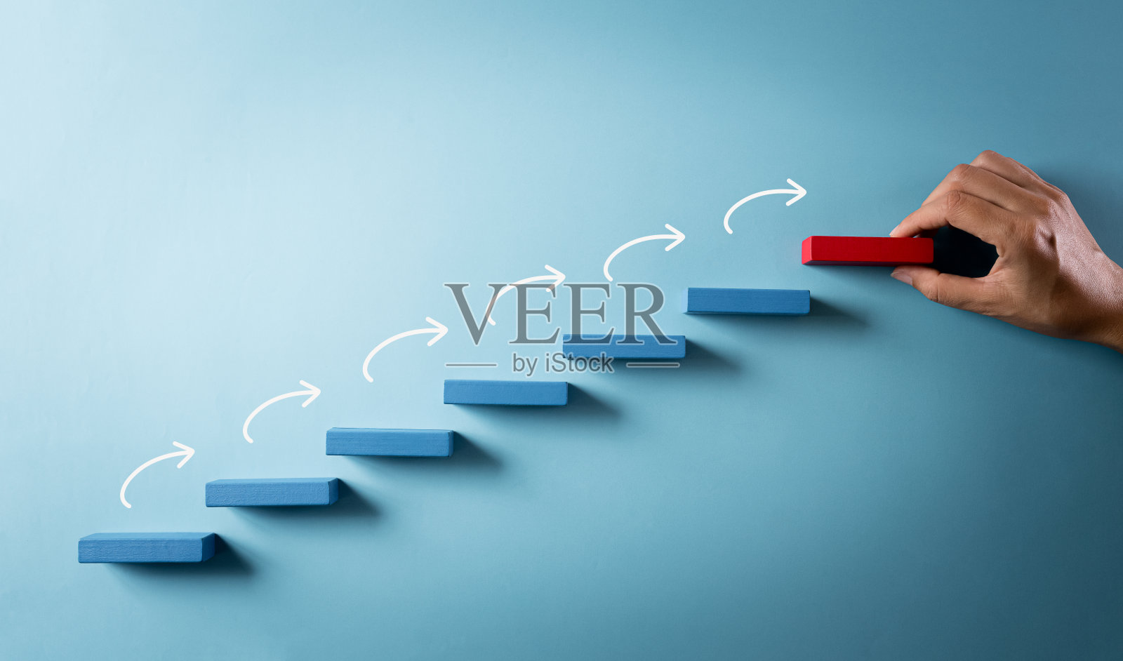 建立成功基础的概念。手持木块堆叠成阶梯，在柔和的背景下成功的商业成长理念。照片摄影图片