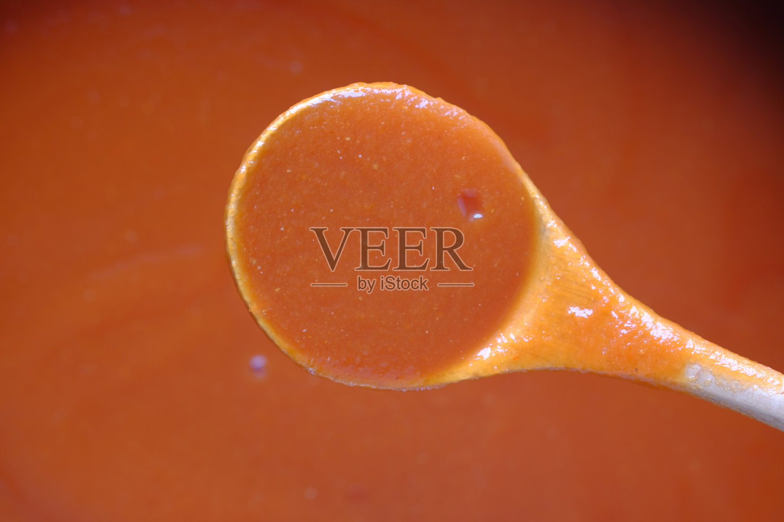 把番茄酱放在木勺上照片摄影图片