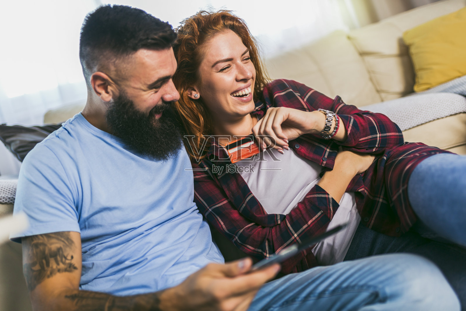 一对年轻情侣在数码平板电脑上购物的照片。照片摄影图片