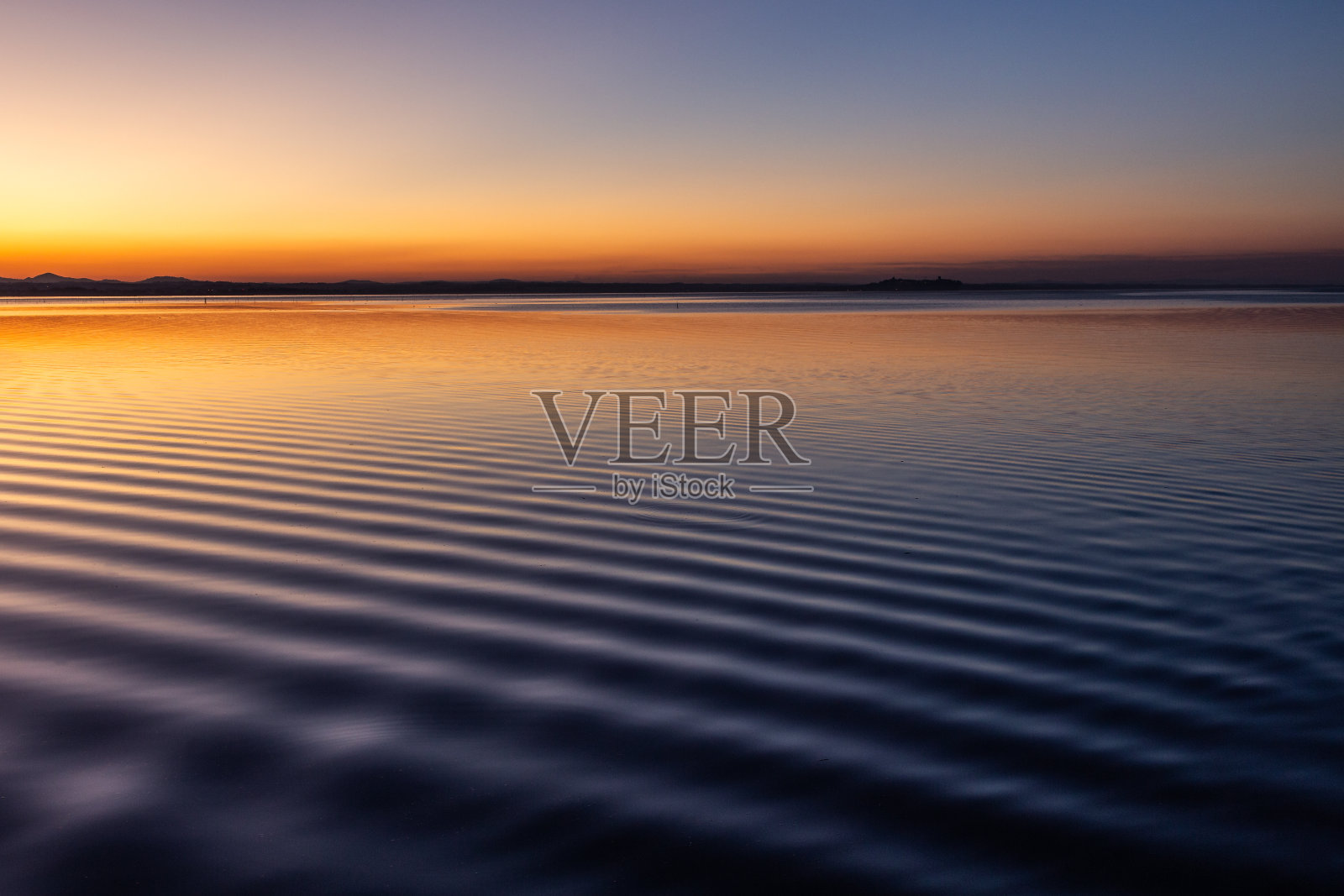 黄昏时分，意大利翁布里亚特拉西梅诺湖上美丽而尖锐的水波照片摄影图片