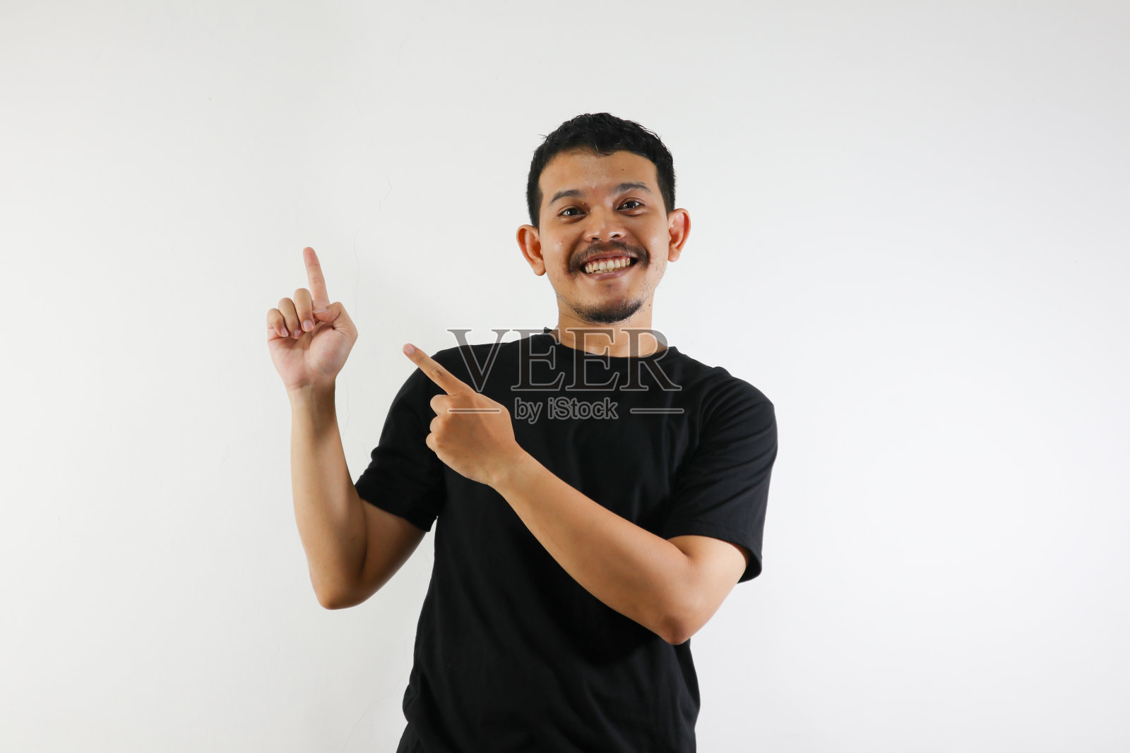 年轻的亚洲成年人用他的双手在白色背景上指着他的上方照片摄影图片