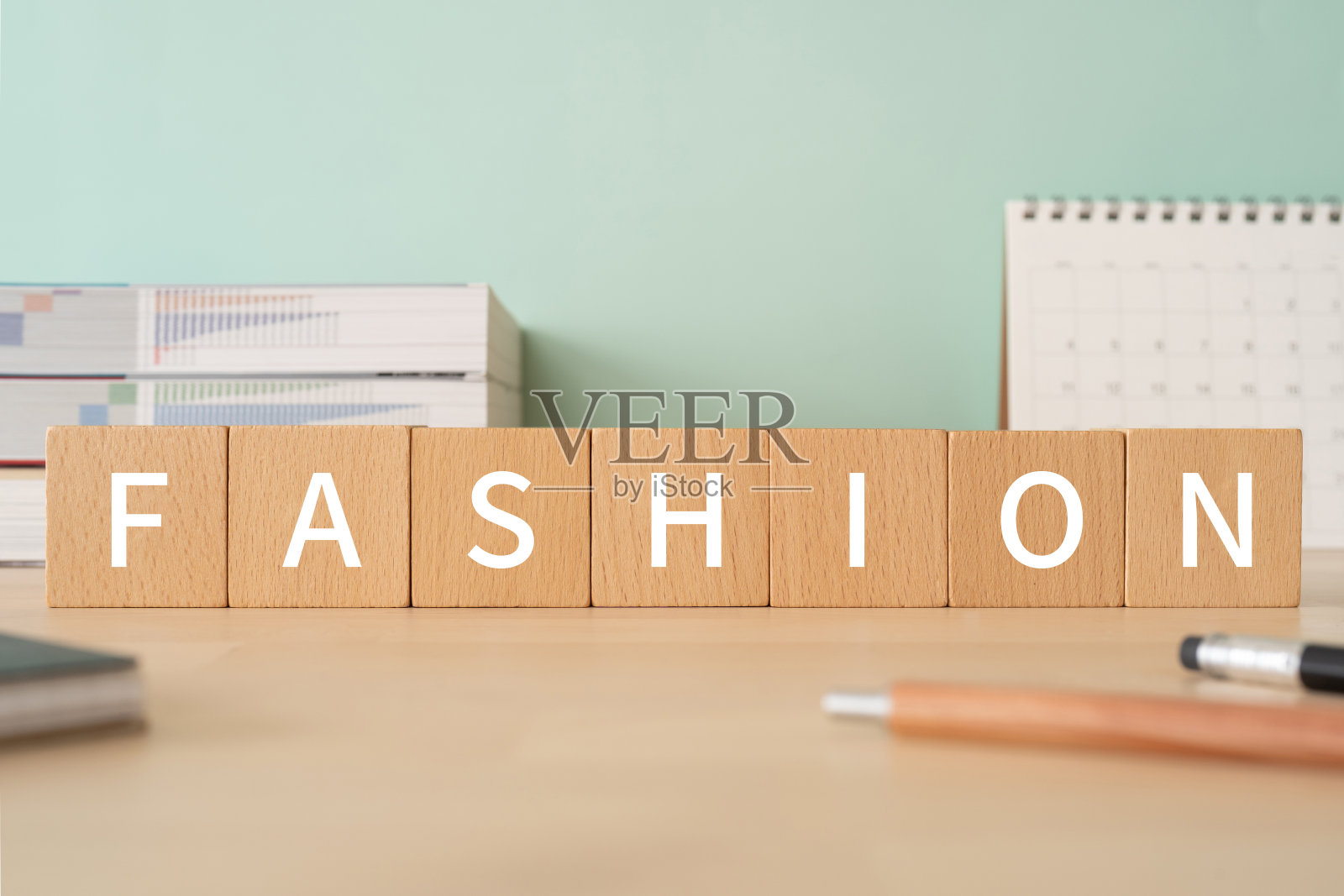 带有"FASHION"文字概念的木块、笔、笔记本和书籍照片摄影图片