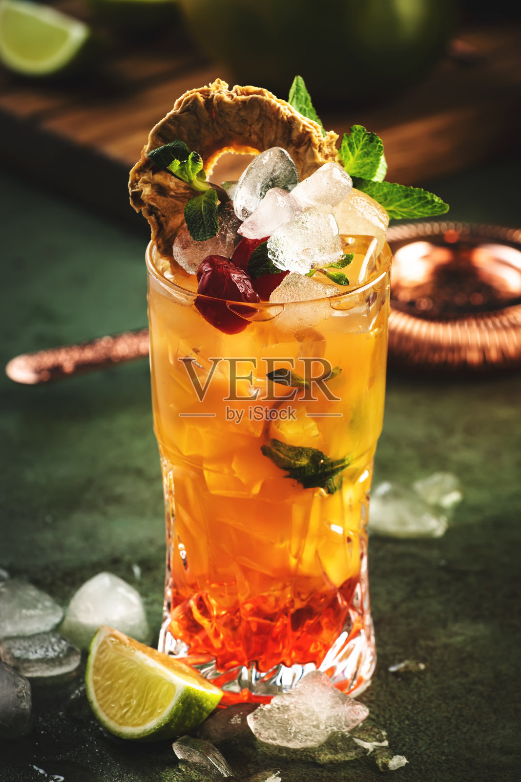 酒精鸡尾酒配伏特加、菠萝汁、芒果、红糖浆和冰块。长饮或夏季冷饮。热带深色背景，棕榈叶和外来水果照片摄影图片