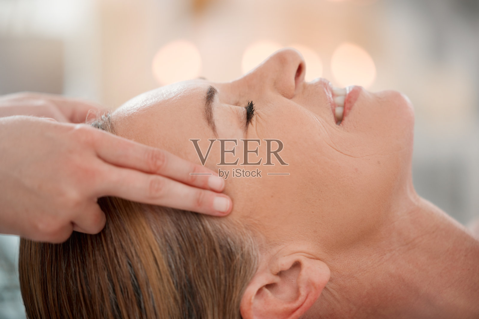 一个女人在水疗中心接受寺庙按摩照片摄影图片