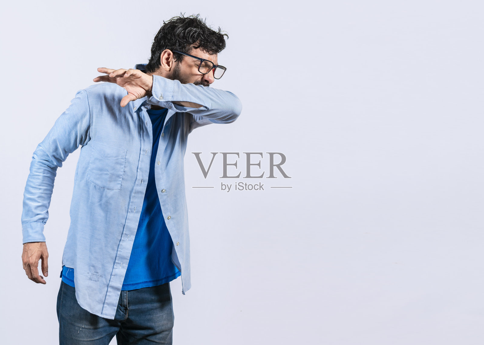 有胡子的男人用手肘打喷嚏，一个男人用手肘打喷嚏在孤立的背景上，男人用手肘打喷嚏感冒的概念照片摄影图片