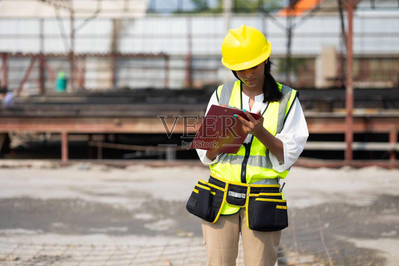 肖像亚洲印度女专业工程师工厂。工厂工业设施中戴安全帽的女工程工人。重工业制造厂。预制混凝土墙照片摄影图片