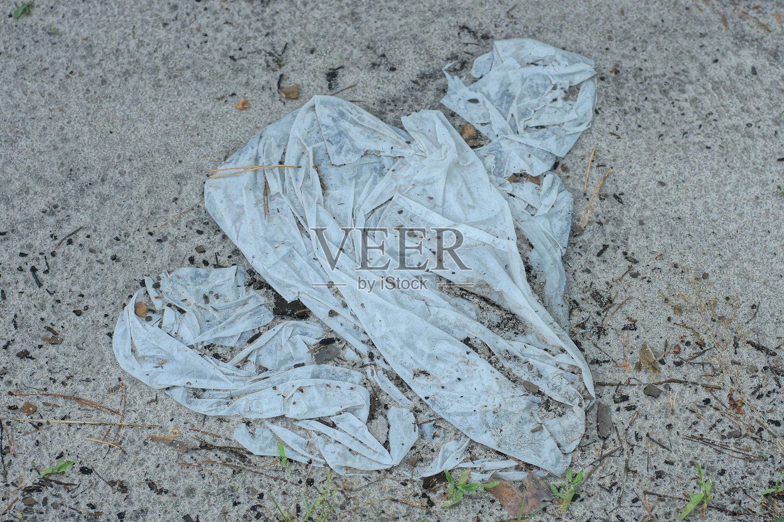 街上一个皱巴巴的白色塑料袋里的垃圾照片摄影图片