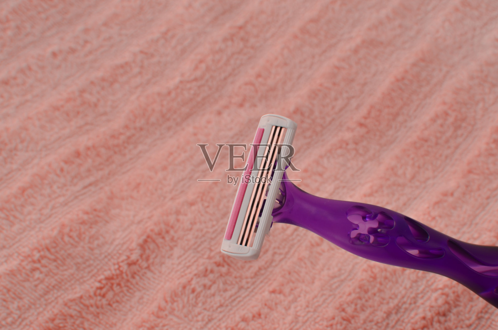 这幅图描绘了一个女性在柔软的环境中剃须，象征着对美容程序的关心和自信。照片摄影图片