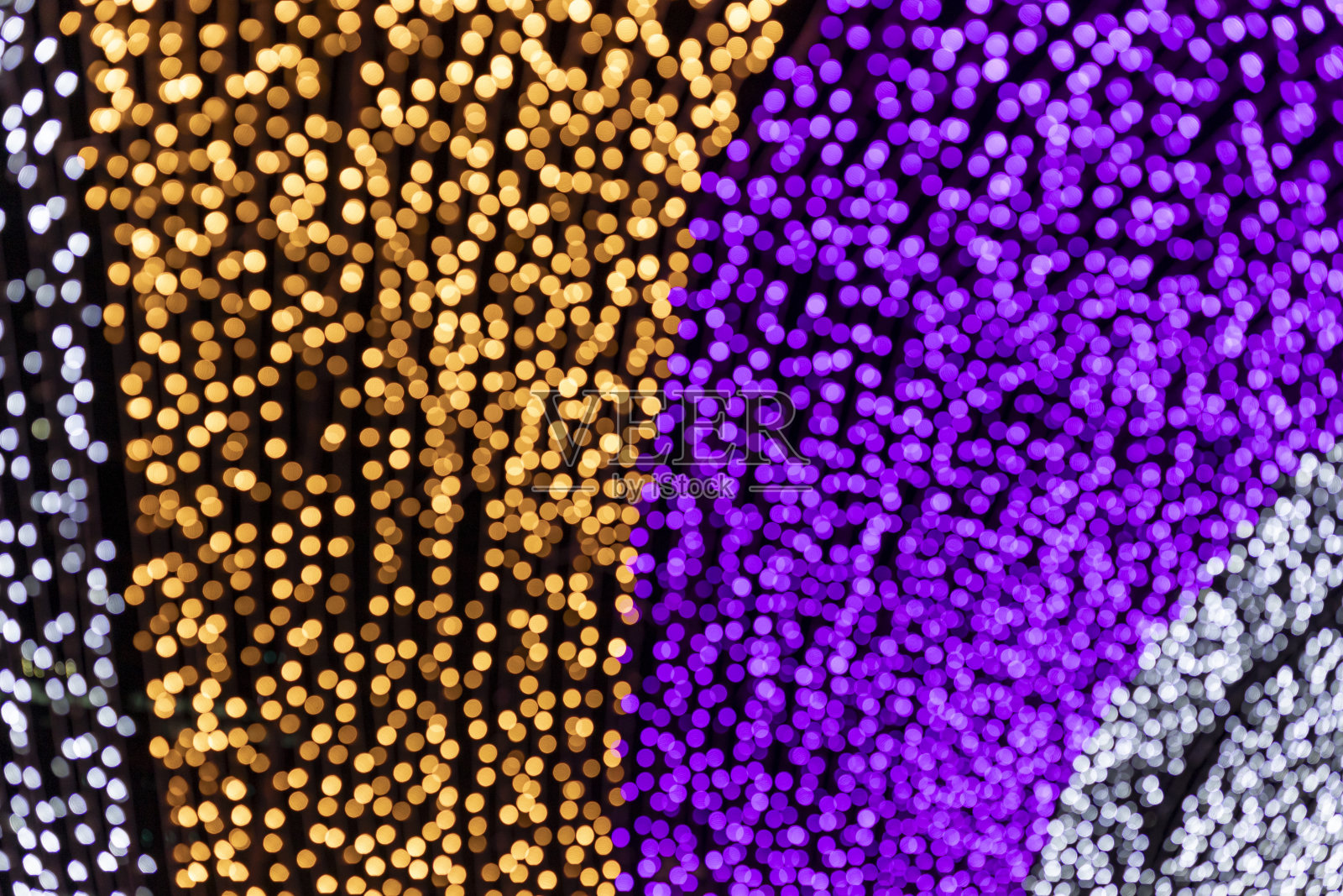 在黑色的背景上，整个画面呈现出一种丰富多彩的散景效果，在夜间被模糊的LED灯捕捉到。照片摄影图片