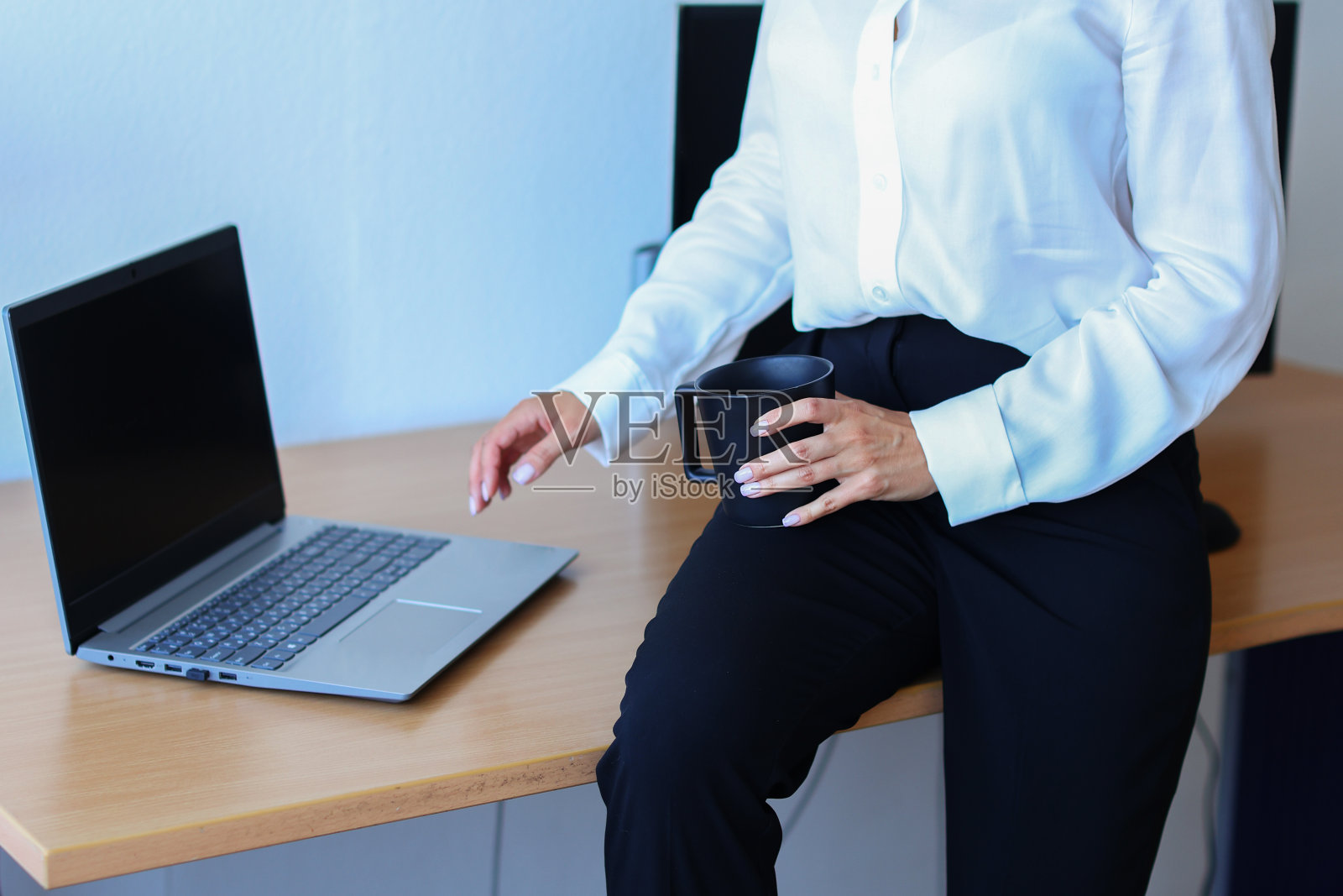 拿着笔记本电脑在办公室喝咖啡的女人照片摄影图片