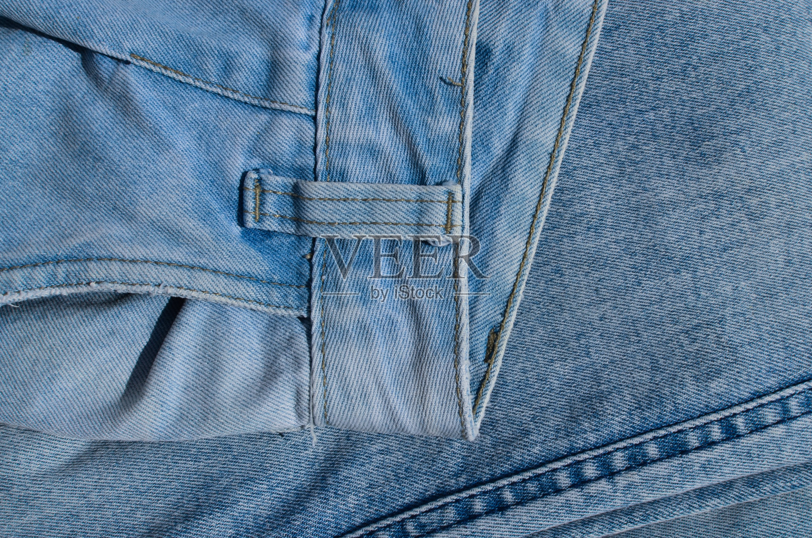 牛仔裤接缝的特写，展示了为服装增添风格和个性的对比线条。完美的时尚和服装项目。照片摄影图片