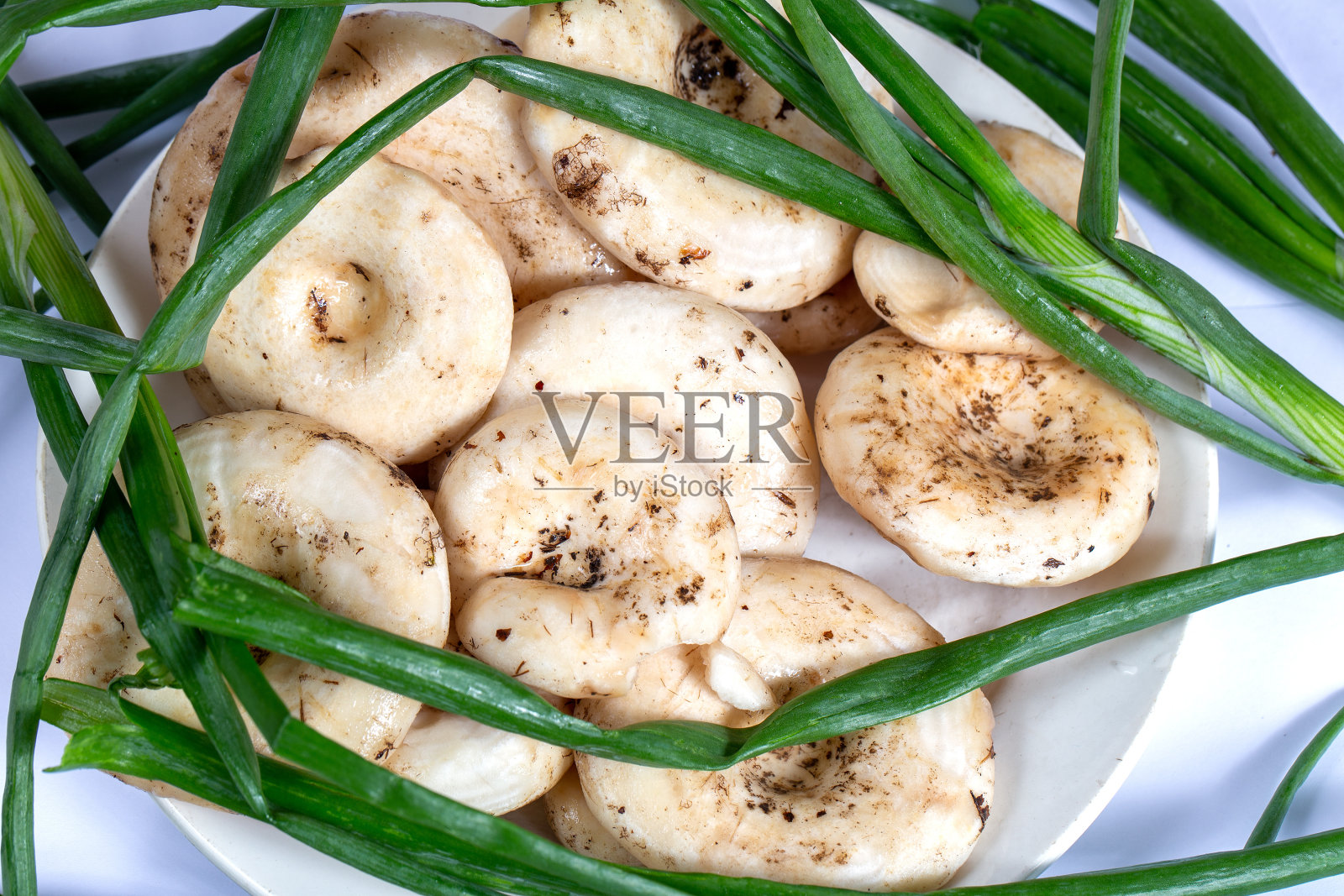 新鲜的生牛奶蘑菇配上大葱照片摄影图片