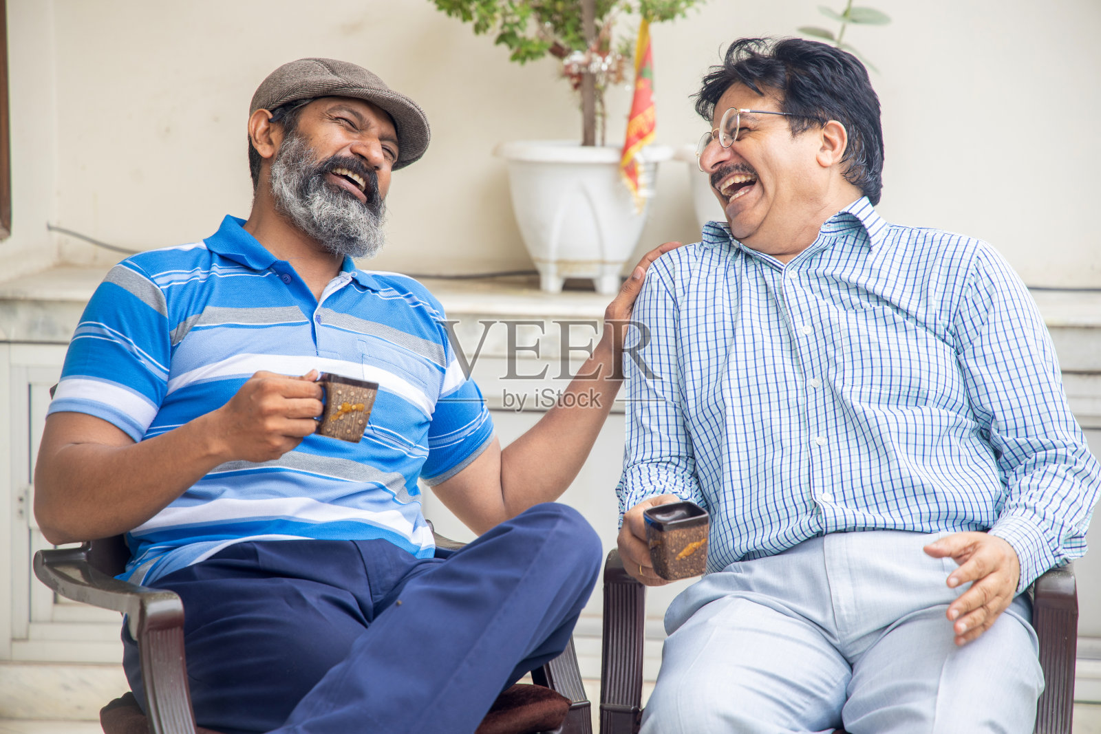 快乐的印度成熟朋友一起享受早茶或咖啡。家庭生活或退休生活。照片摄影图片