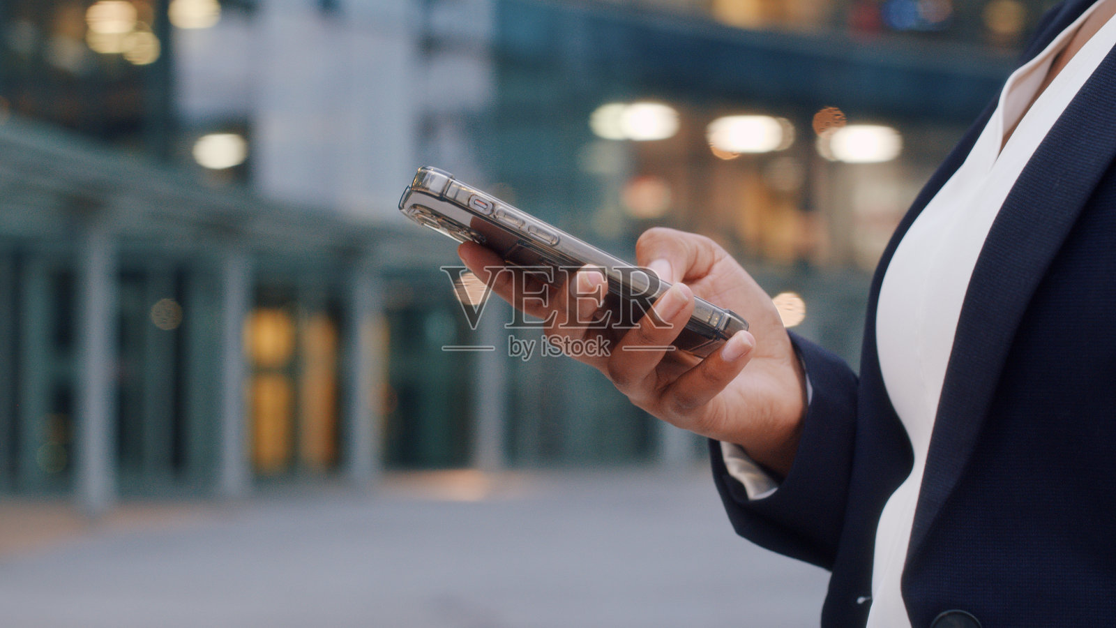 一个年轻女子的手正在使用智能手机发送信息。照片摄影图片