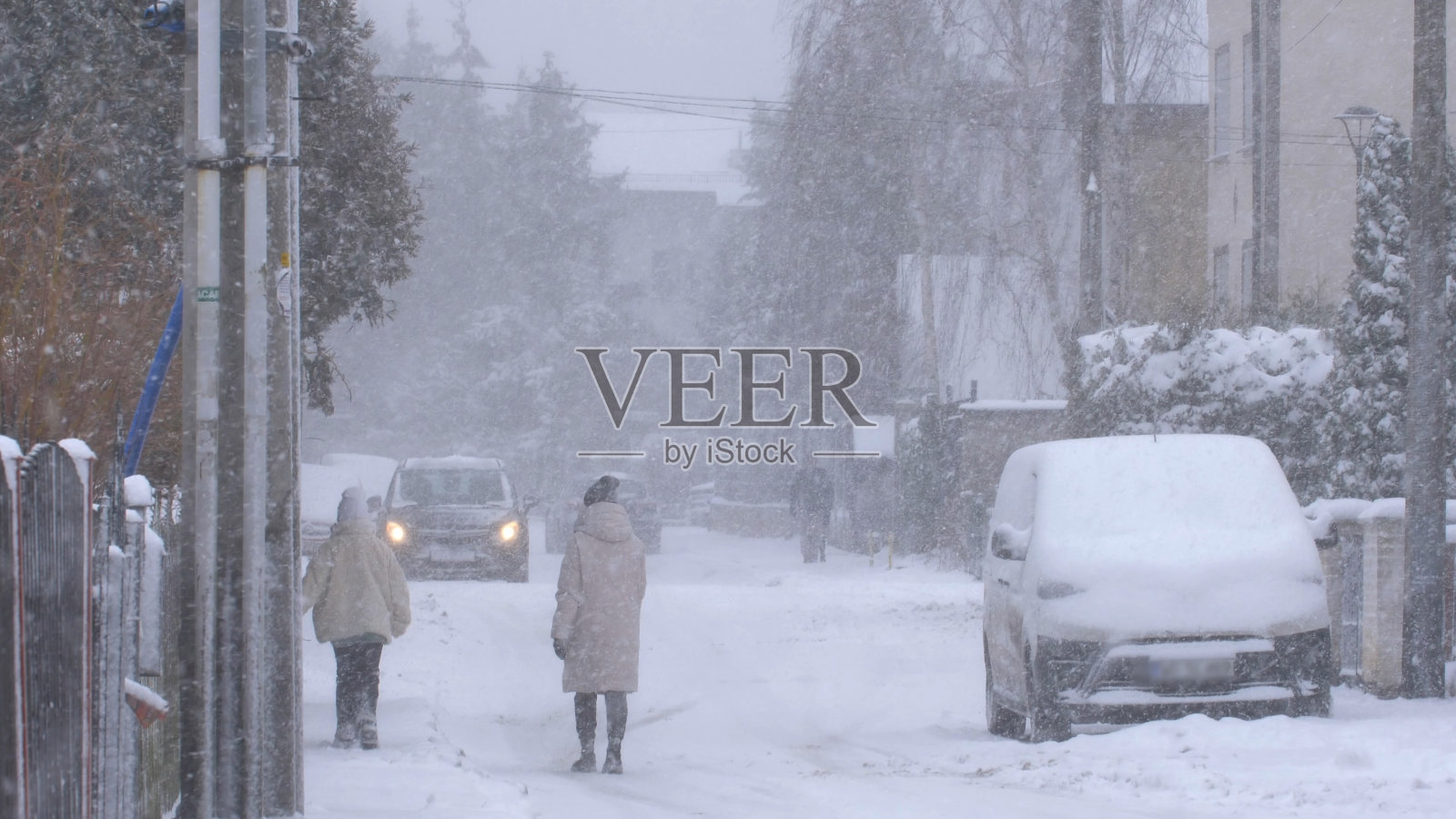 冬天暴风雪中街坊街道上的无名行人慢镜头照片摄影图片