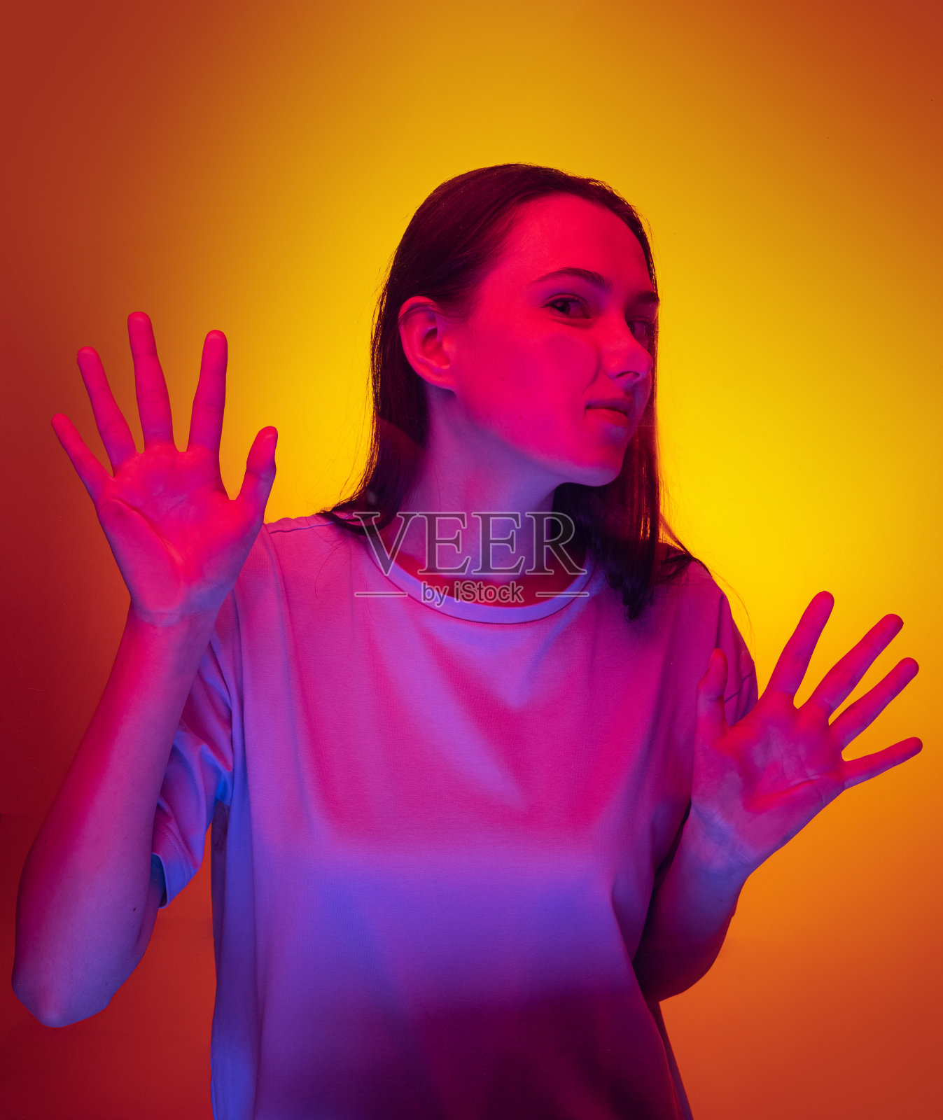 年轻有趣的女孩，学生靠在透明的玻璃孤立在黄色的背景。特写镜头。照片摄影图片