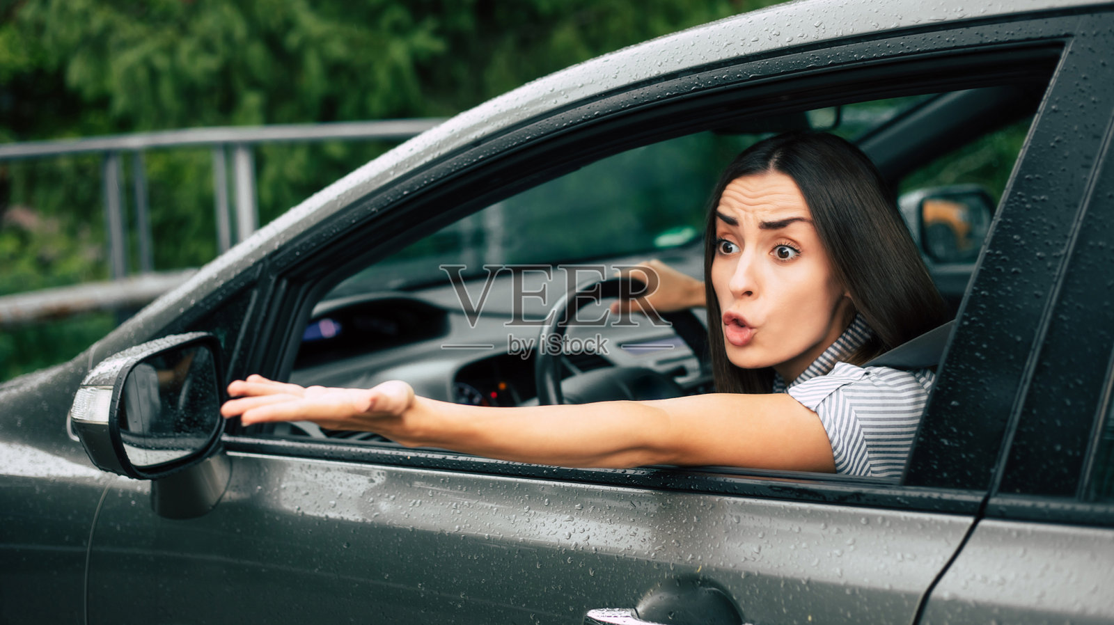 交通堵塞。激进的驾驶员。车祸。特写照片:不高兴的愤怒的女人开着车，对着别人大喊大叫，双手高举在空中。人类的消极表达照片摄影图片