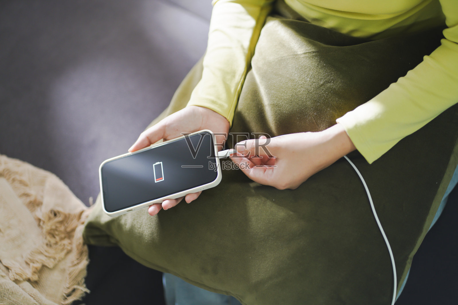 女士用手给电量不足的手机充电。为智能手机插入充电器Â与能源银行电力银行电力充电器现代生活方式的能源技术概念。照片摄影图片