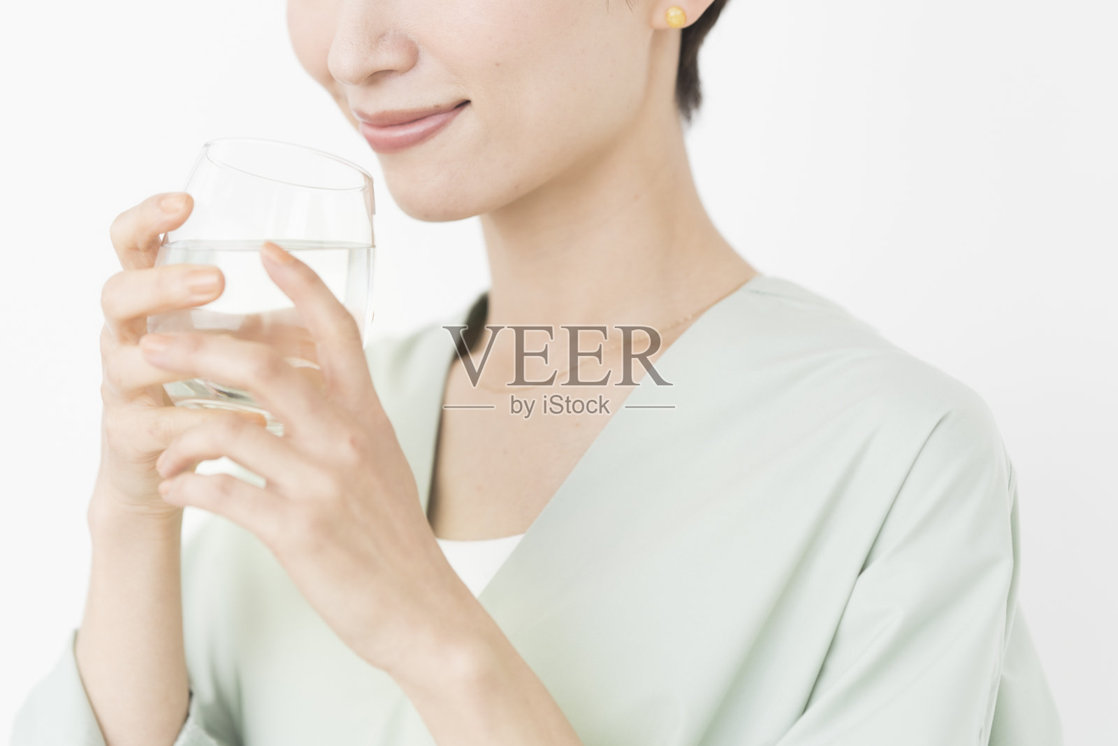 一位亚洲妇女正在喝一杯水。照片摄影图片