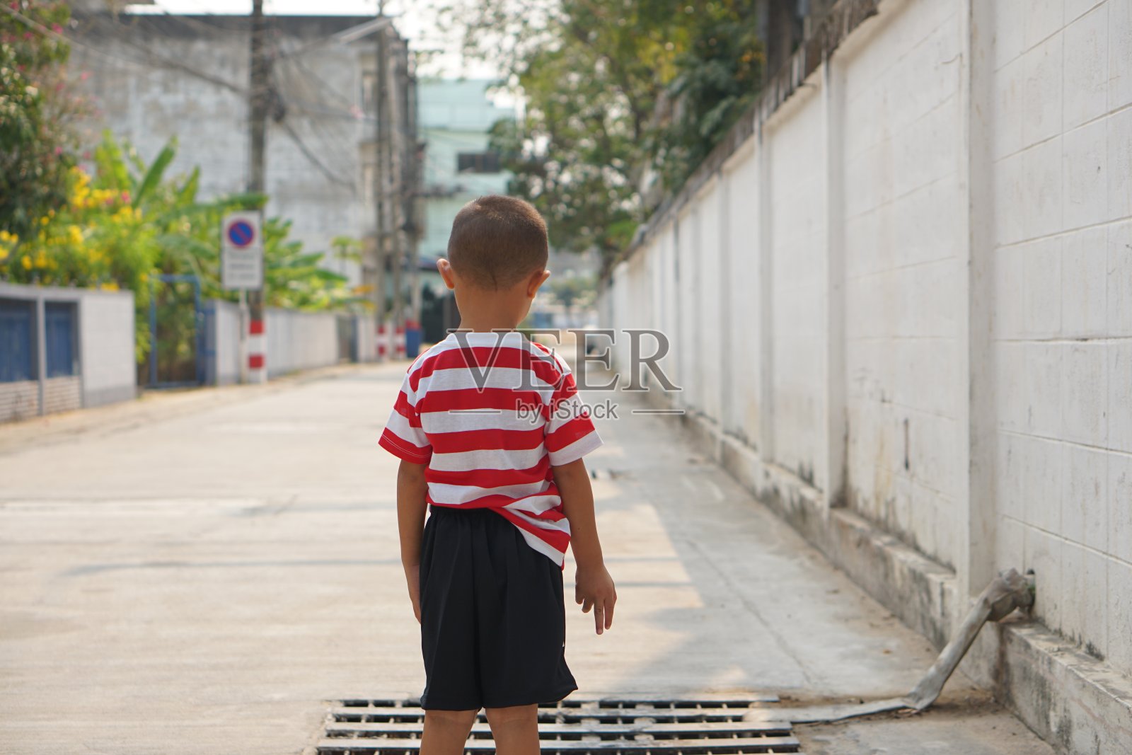 男孩透过下水道往外看照片摄影图片