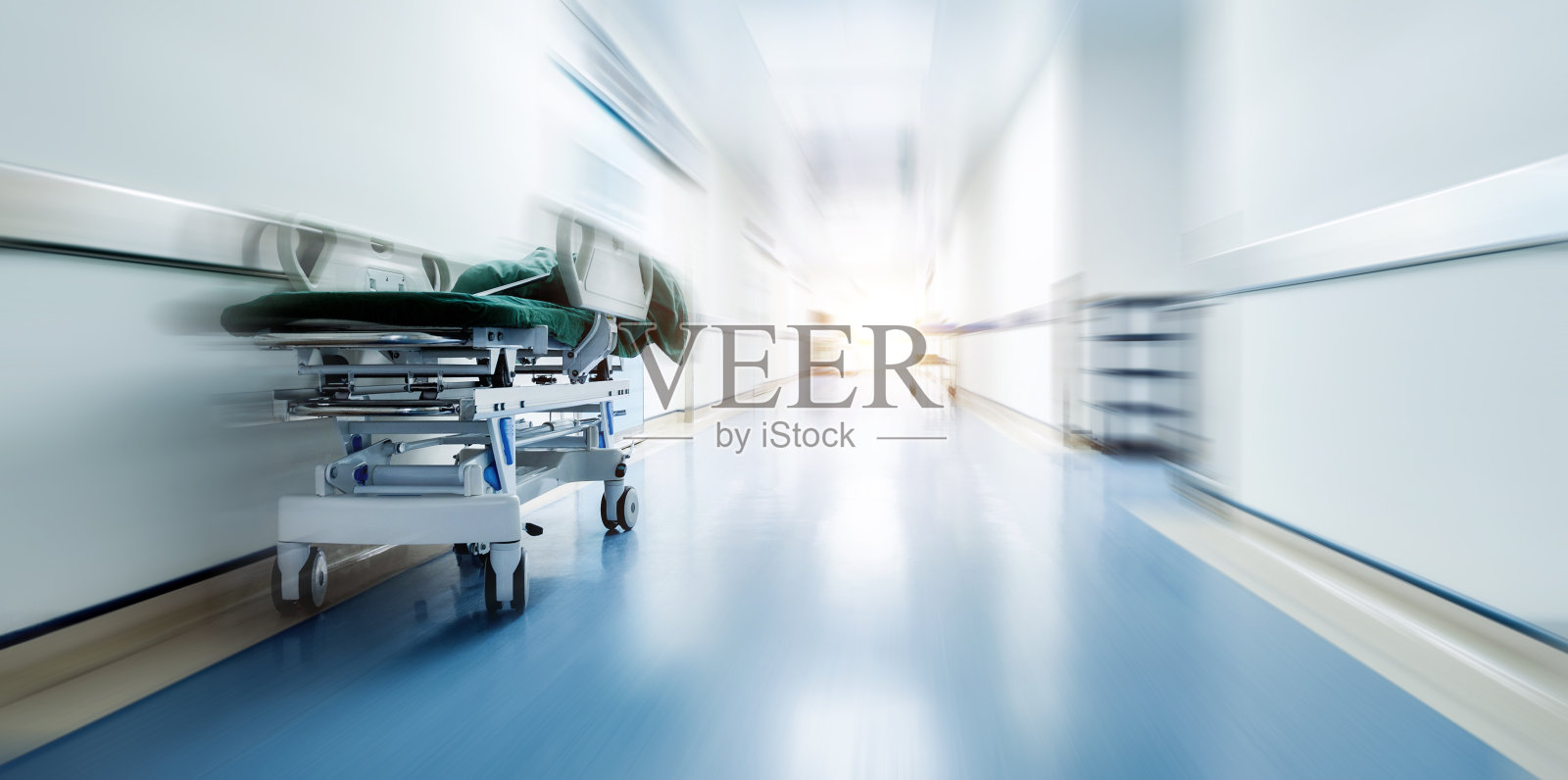 空荡荡的医院走廊上只有一张床，动作模糊照片摄影图片