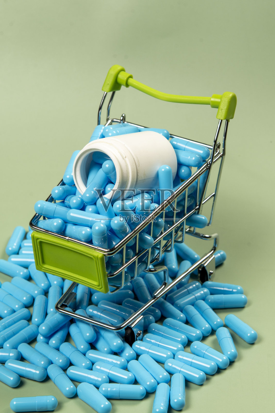 微型购物车里的蓝色药胶囊照片摄影图片