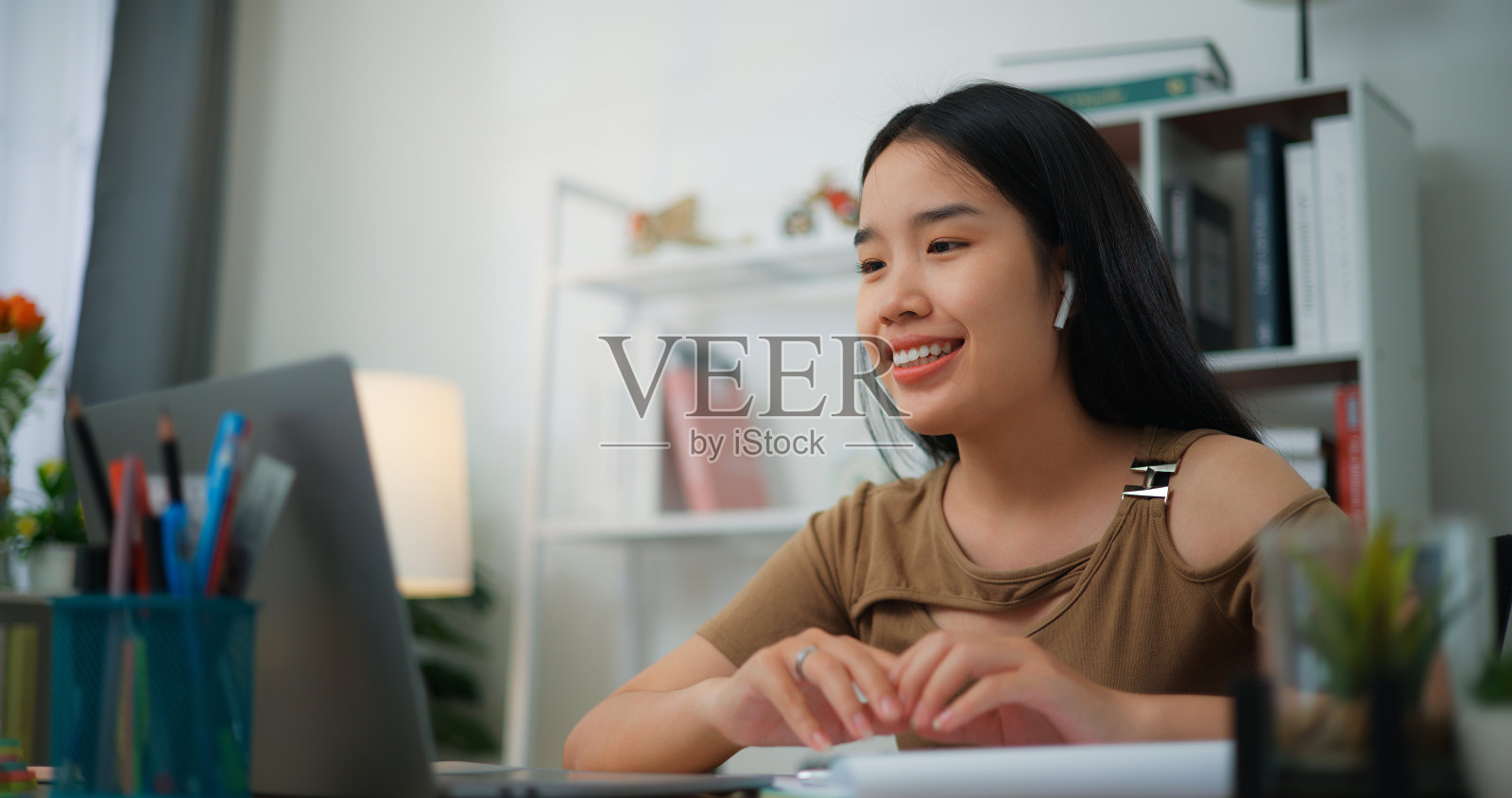 年轻的亚洲女性在桌子上用笔记本电脑工作照片摄影图片