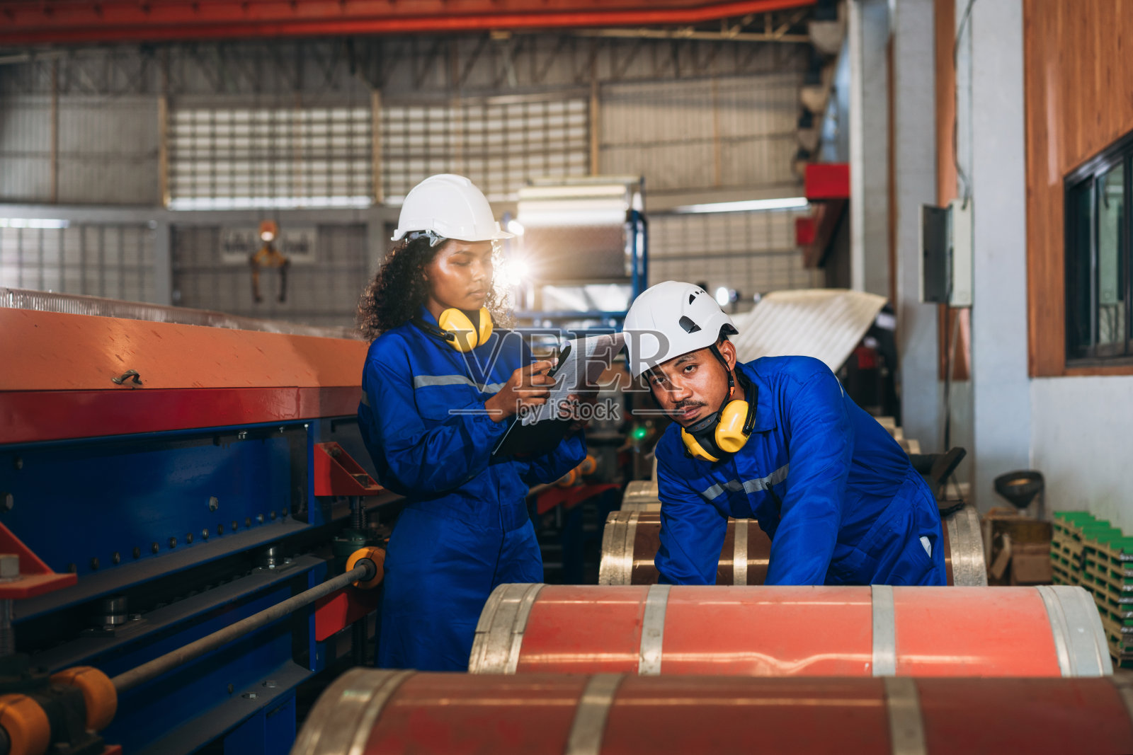 在工厂机器中检查和检查机器的产业工人。工业钣金技术人员。领班检查材料或机器。照片摄影图片