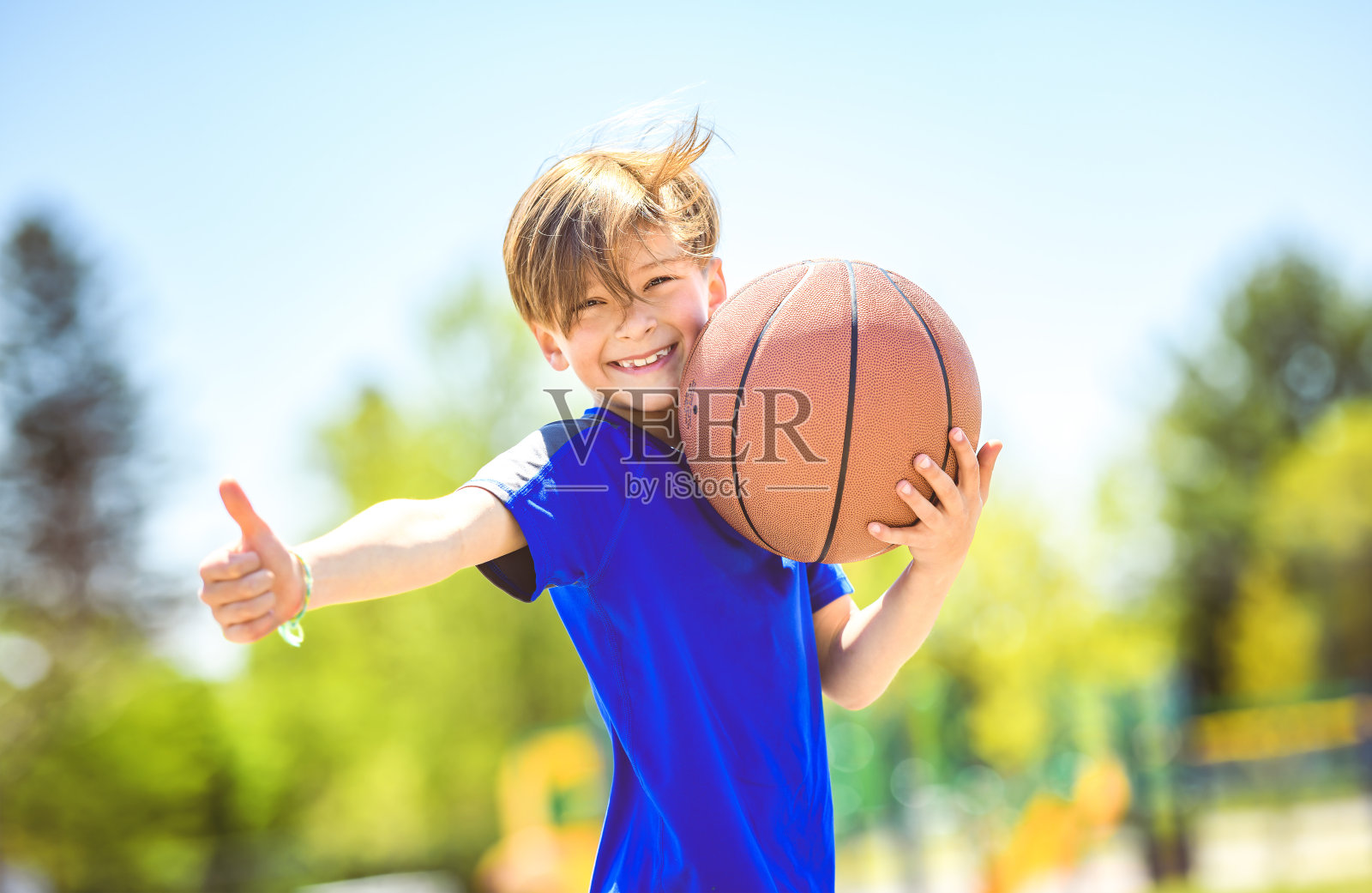 一个小男孩在公园里打篮球的照片照片摄影图片