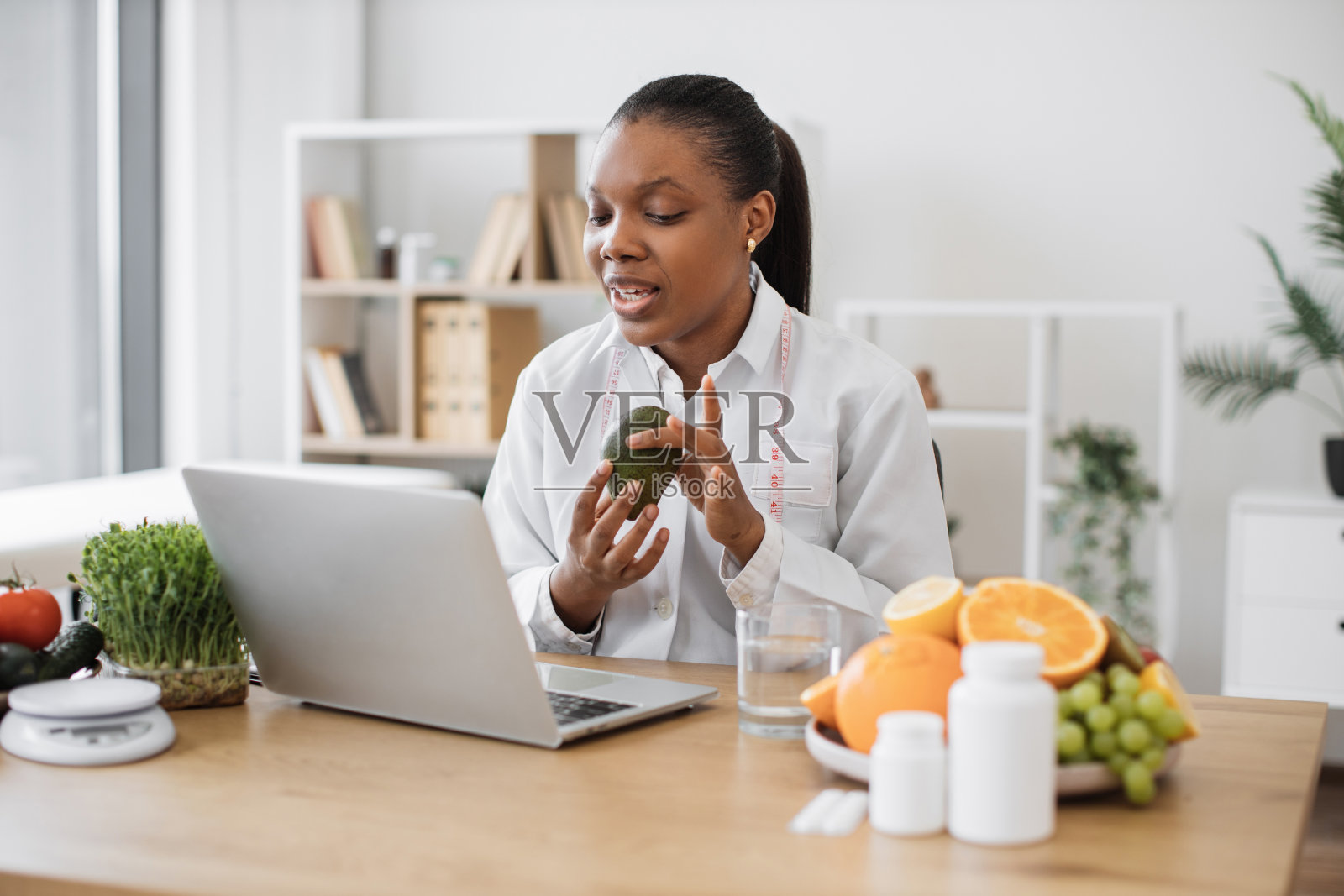 专家在网上咨询病人时展示牛油果照片摄影图片