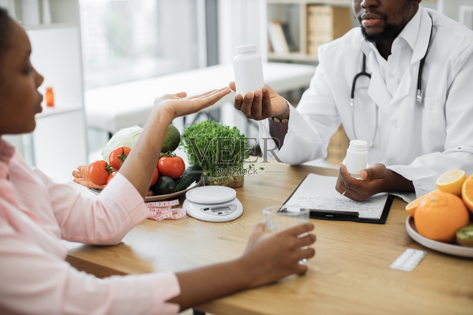 非裔美国医生在诊所给病人服药照片摄影图片