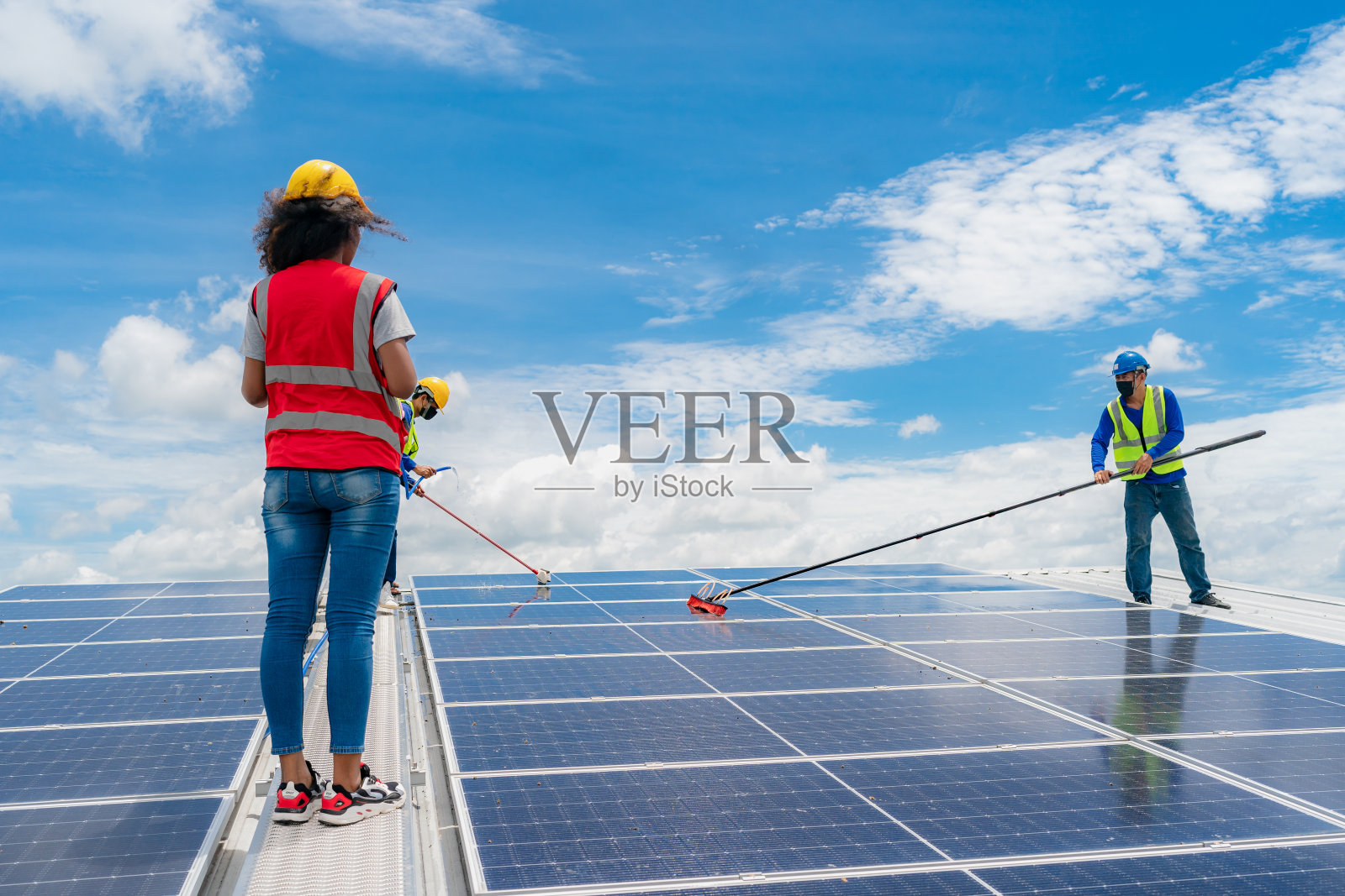 专业工人用毛刷清洗太阳能板，用水清洗厂房屋顶结构。技师使用拖把清洁脏物和灰尘，采用绿色电力能源技术照片摄影图片