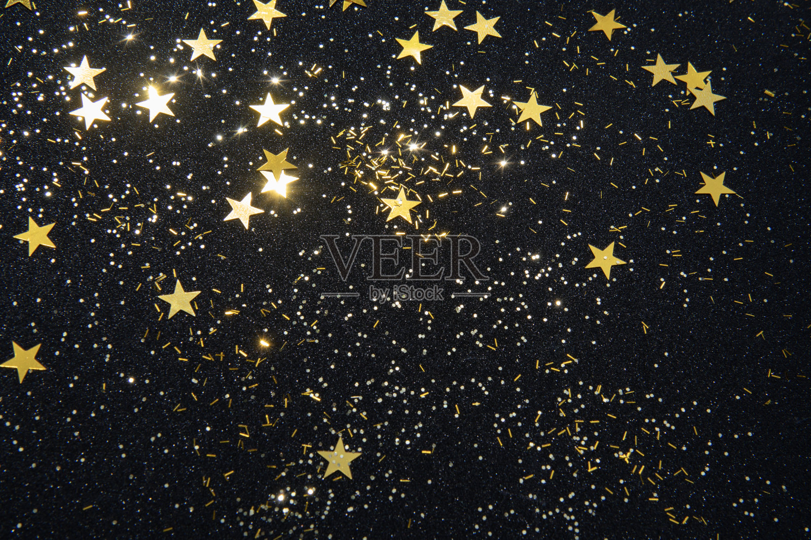 金色的星星五彩纸屑和闪闪发光的黑色闪闪发光的背景为圣诞项目照片摄影图片
