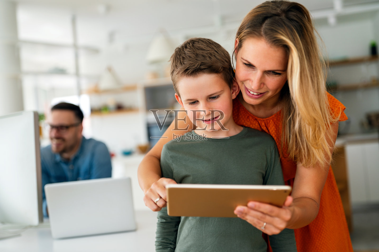 母亲和孩子使用数字平板电脑进行电子学习。教育家庭数码设备儿童概念。照片摄影图片