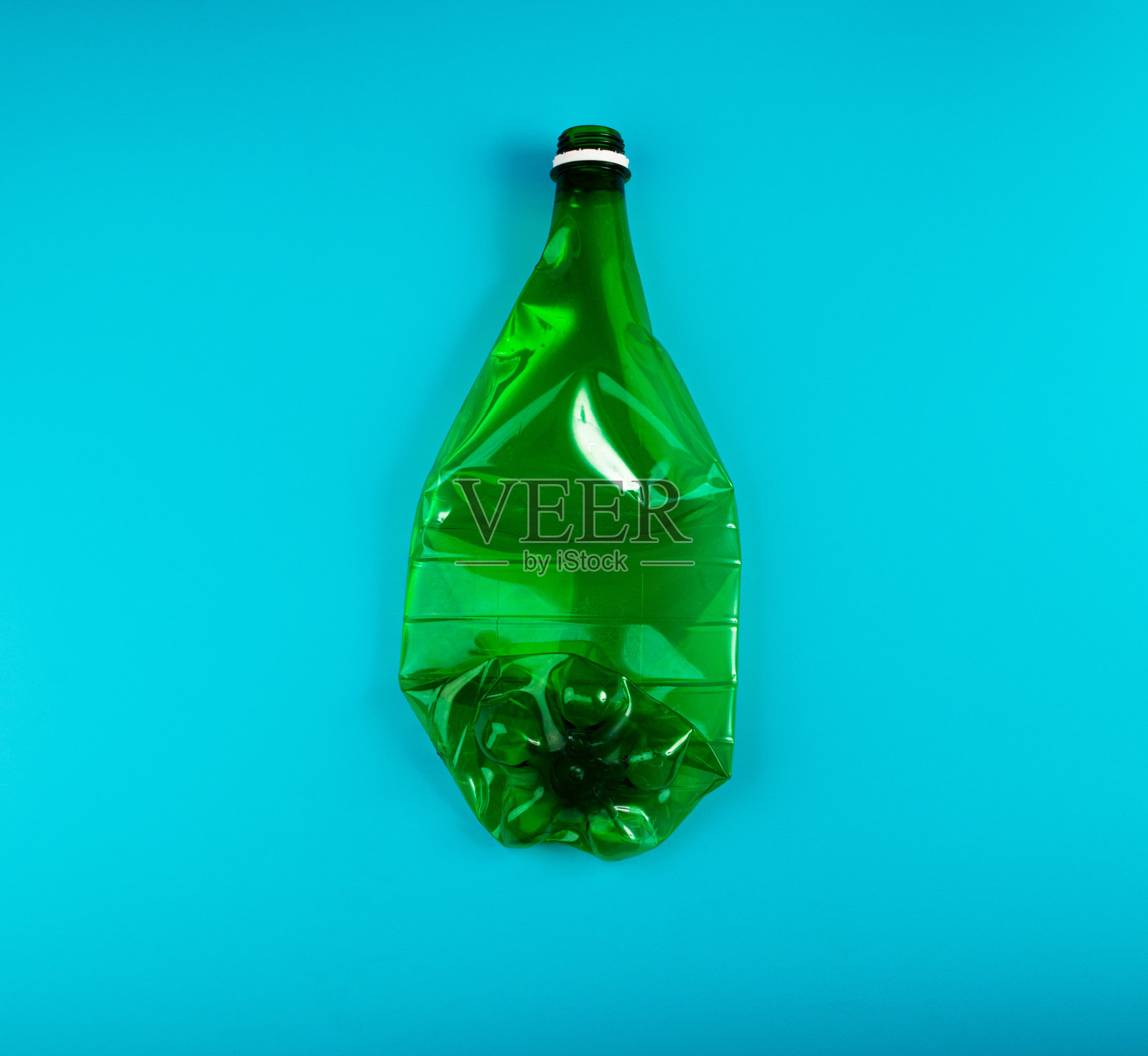 绿色空塑料瓶，皱巴巴的塑料瓶，全球污染概念照片摄影图片