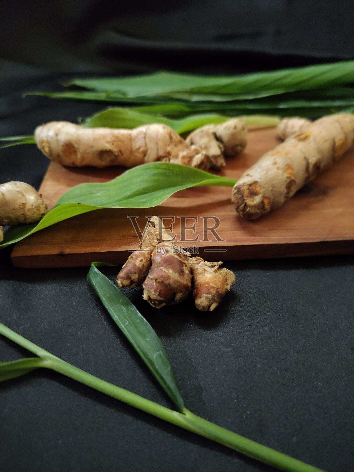 新鲜姜、姜黄和芳香姜，还有一些绿叶照片摄影图片