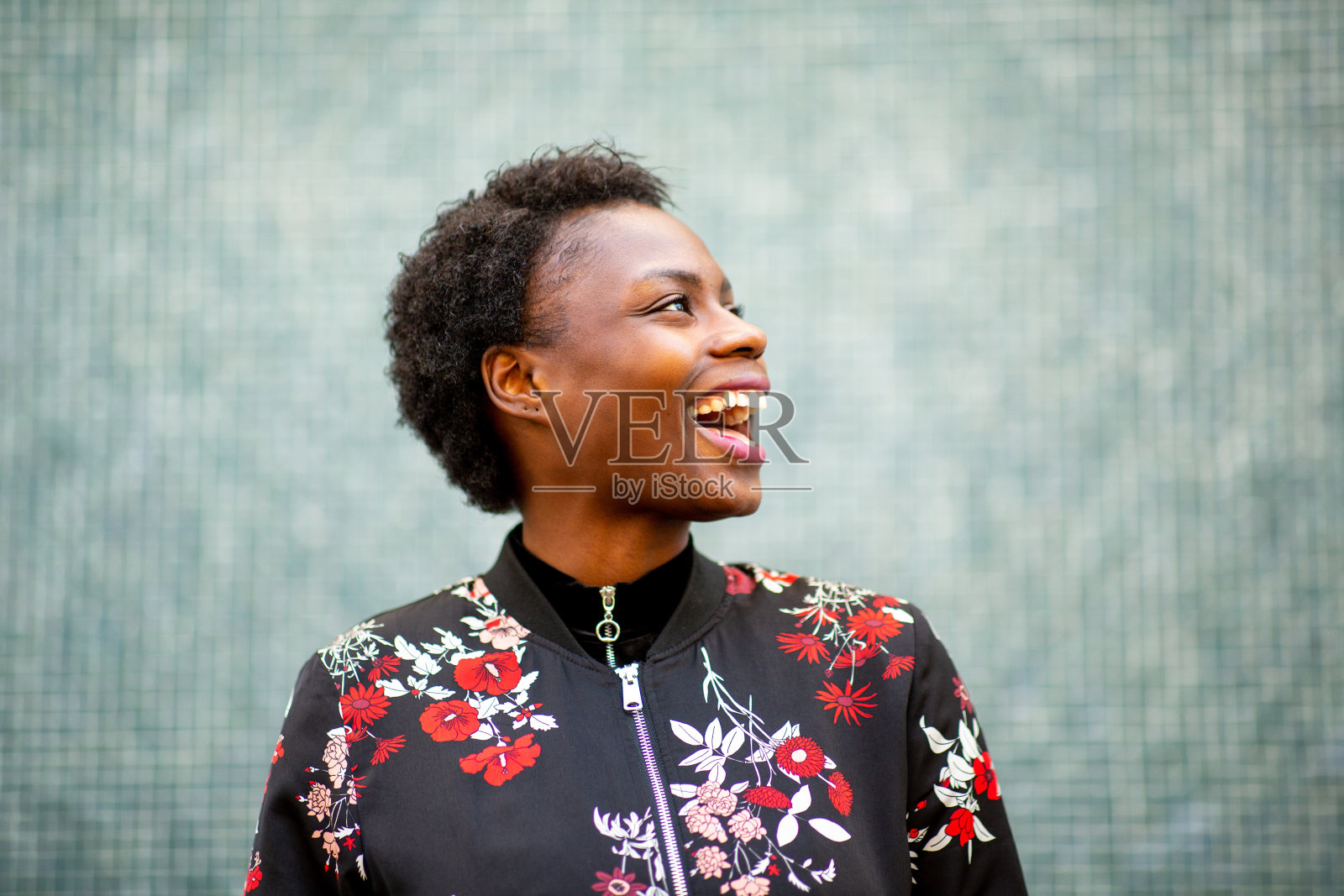 开朗的年轻非洲女人看着别处笑着照片摄影图片