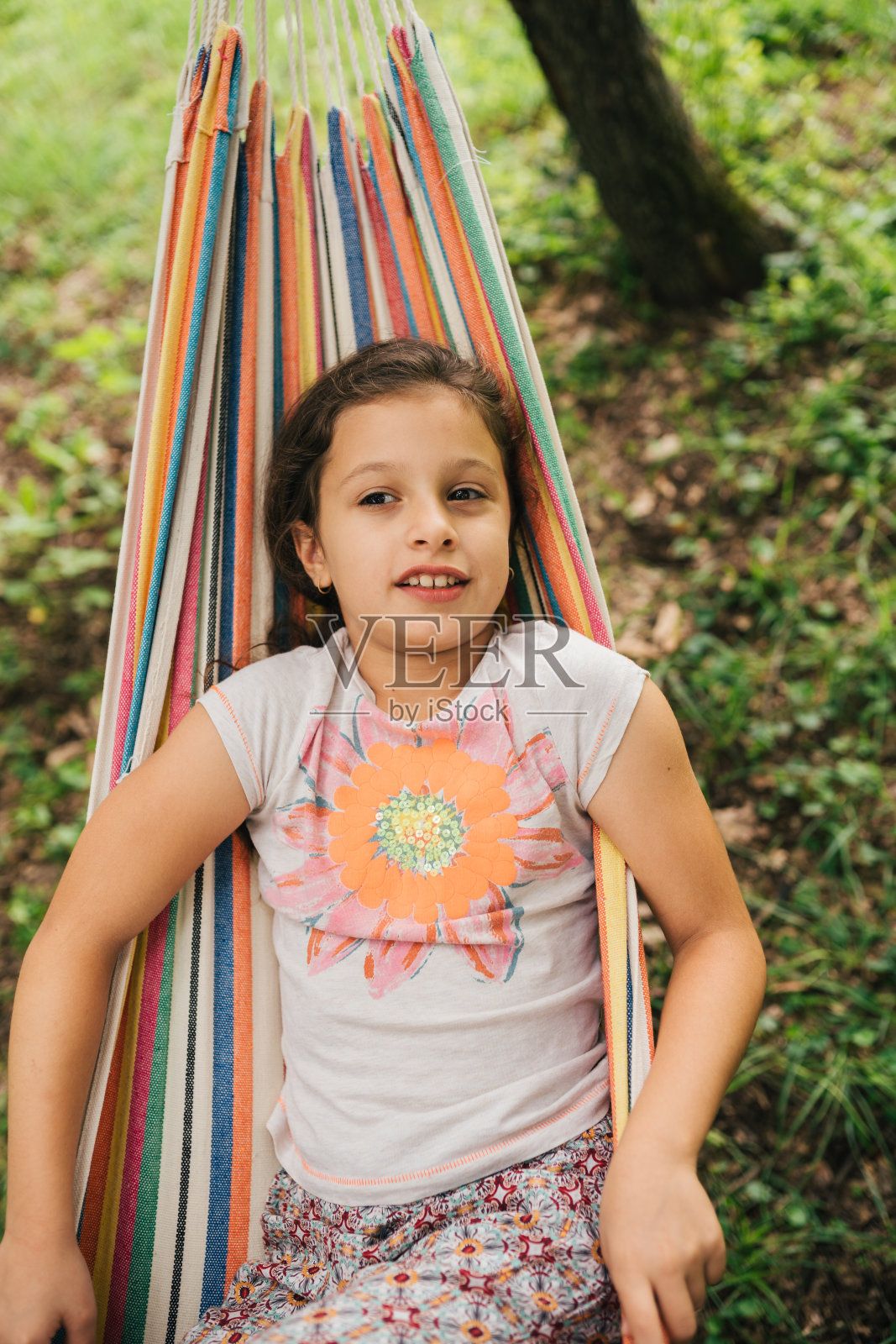 上图是一个女孩在大自然中躺在吊床上休息的照片照片摄影图片