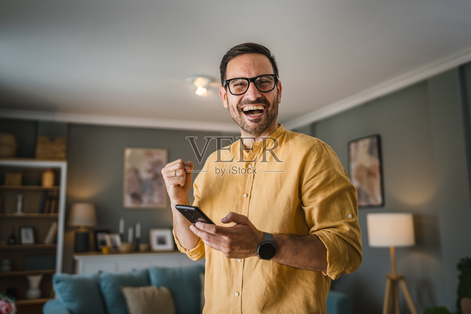 一个戴着眼镜的成年男子站在家里开心地笑着照片摄影图片