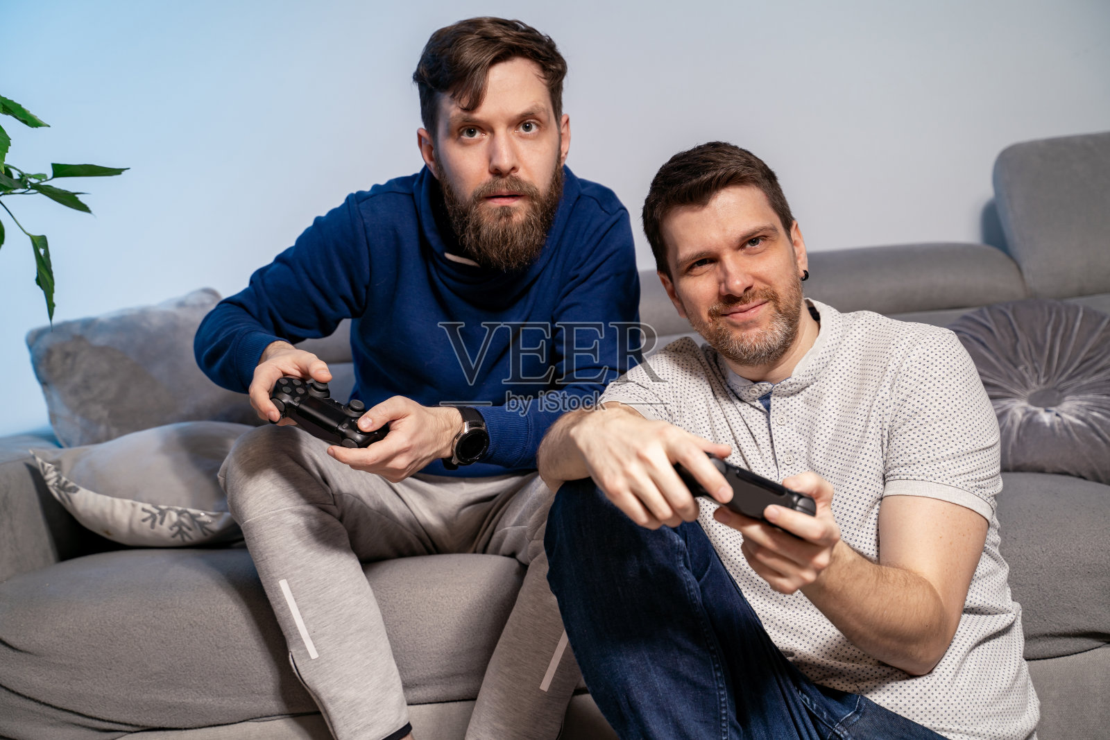 两个最好的男性朋友晚上在家用手柄玩电子游戏照片摄影图片