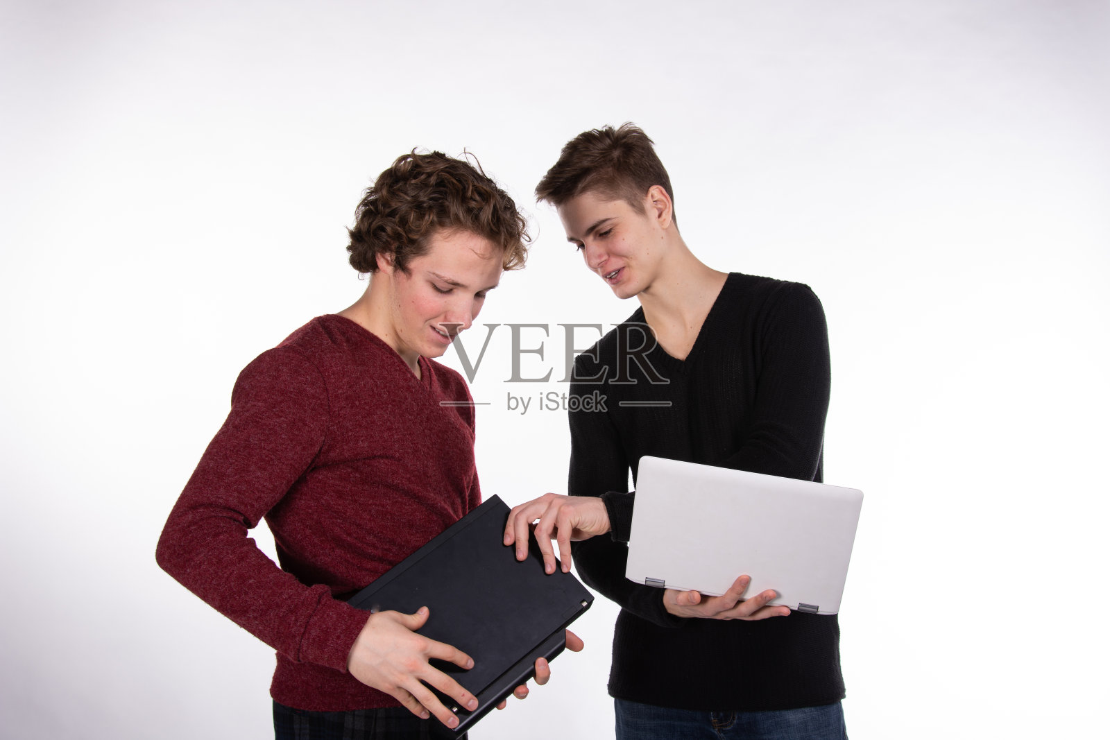 两个年轻漂亮的学生拿着笔记本电脑。照片摄影图片